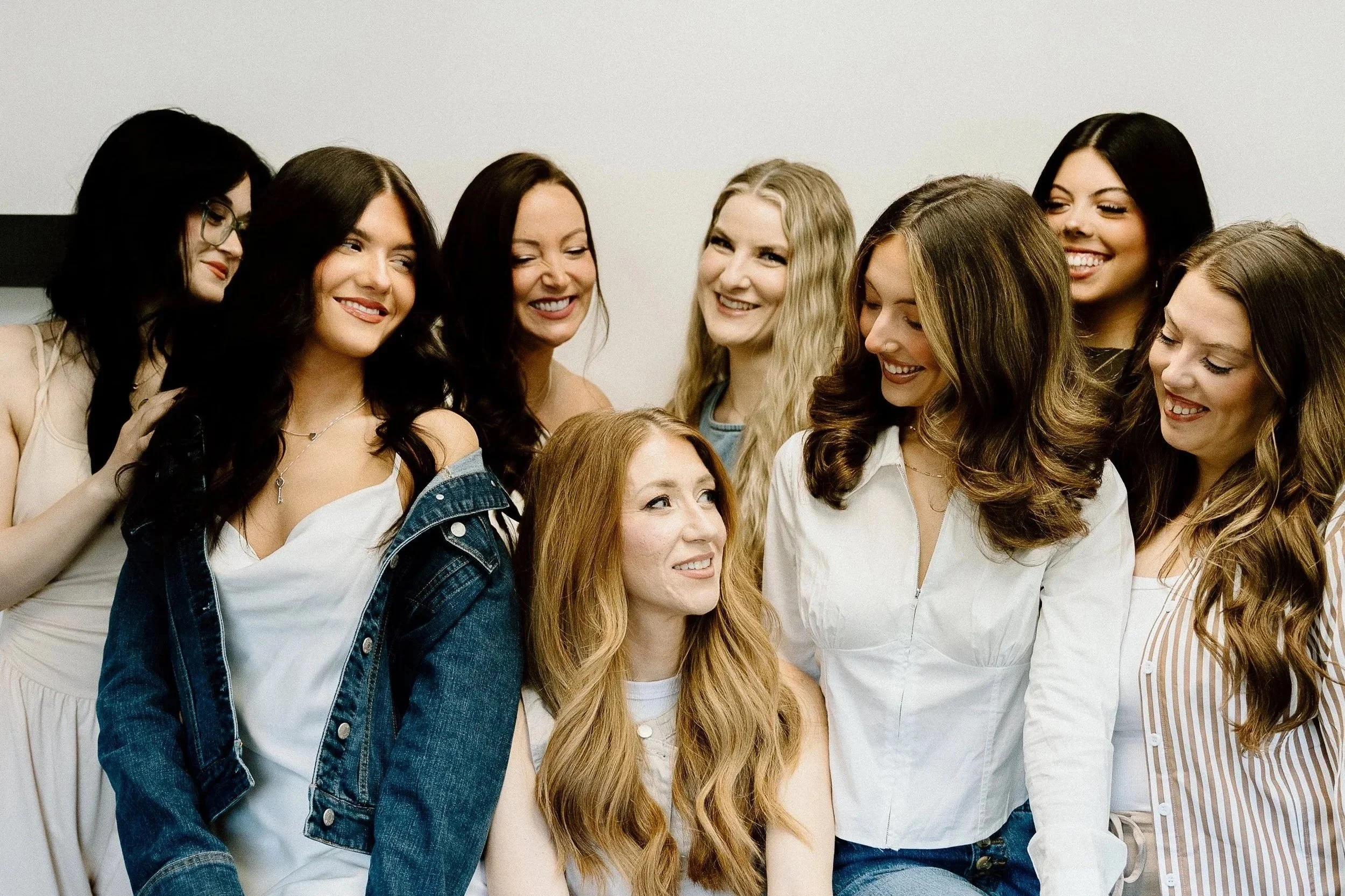 Group of smiling women standing close together in a casual setting.