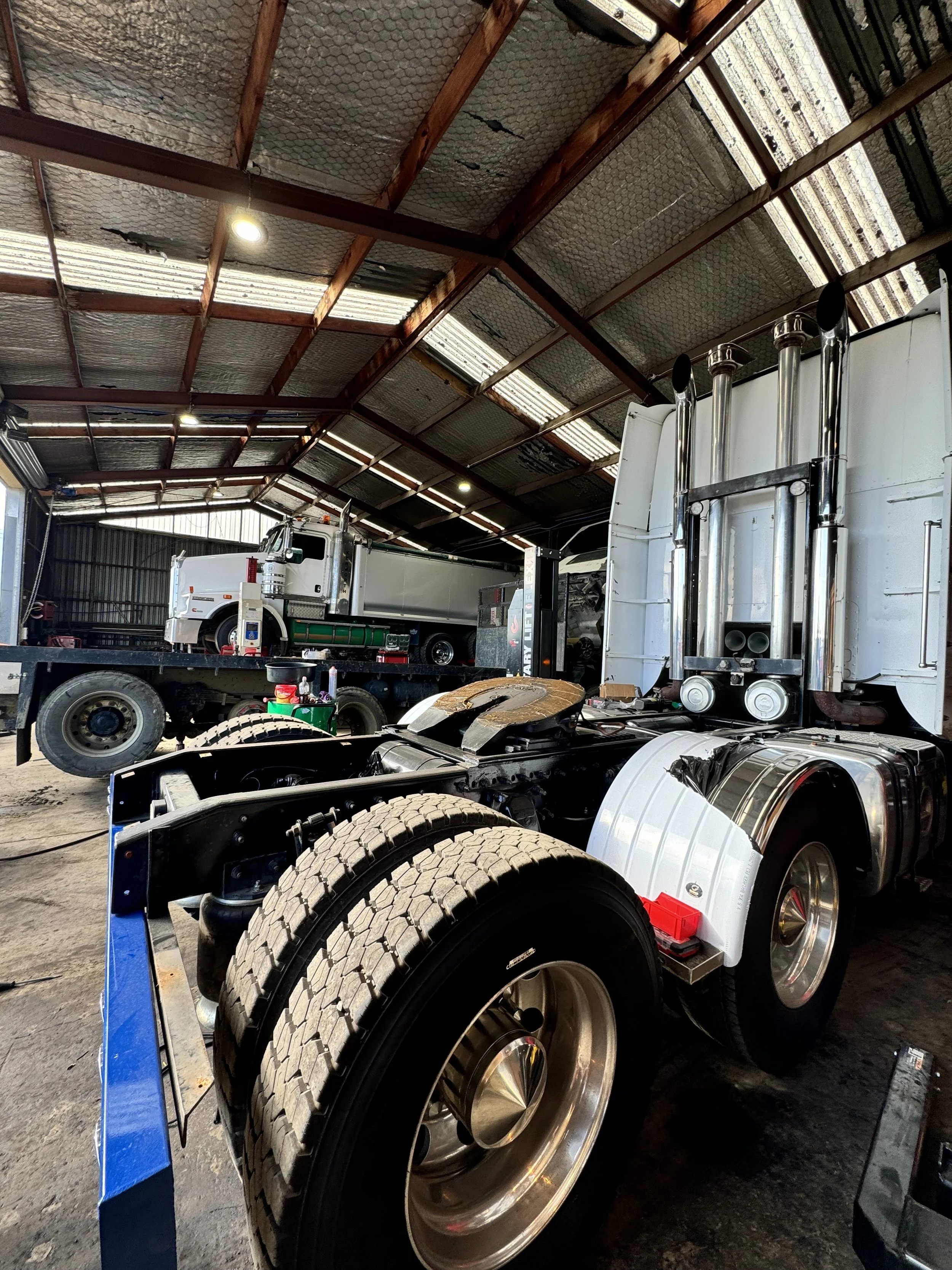 Inside a workshop with trucks being worked on