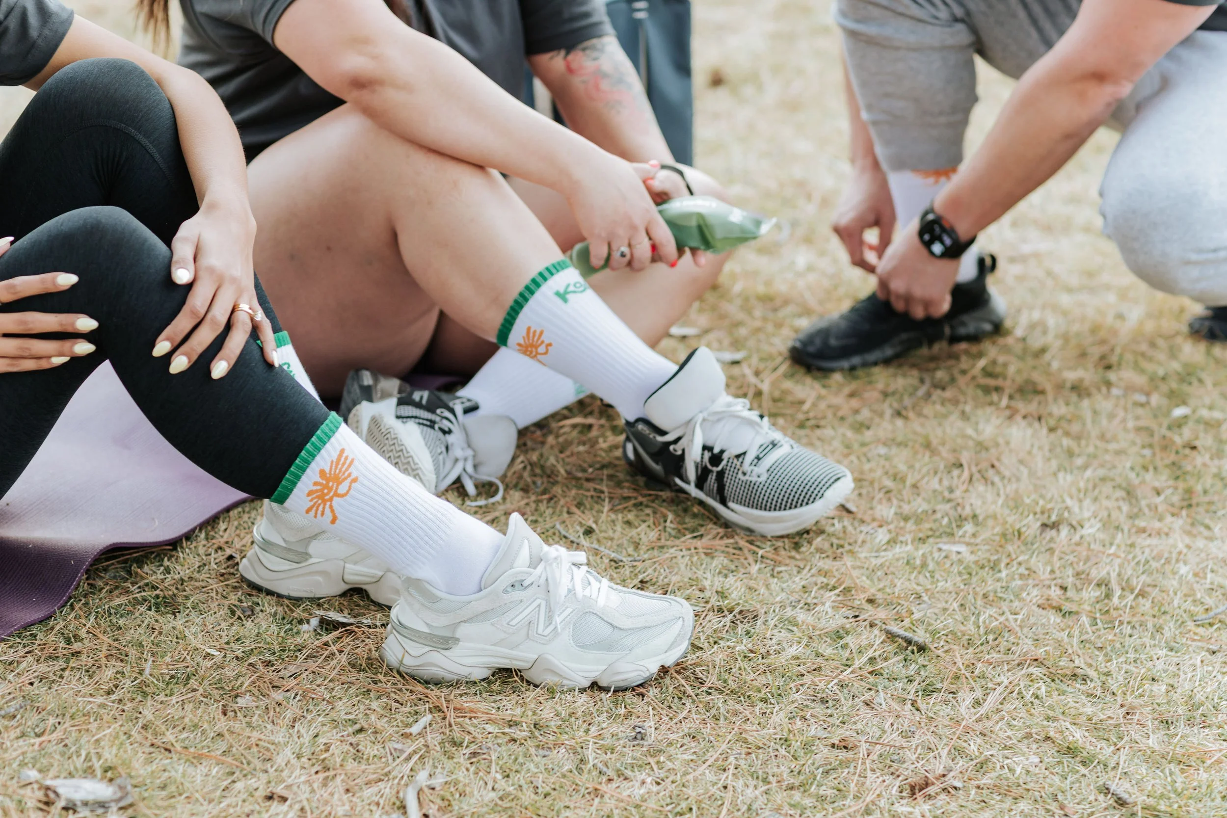 Someone sitting on the grass wearing Kanvas Movement Sunny Stride socks