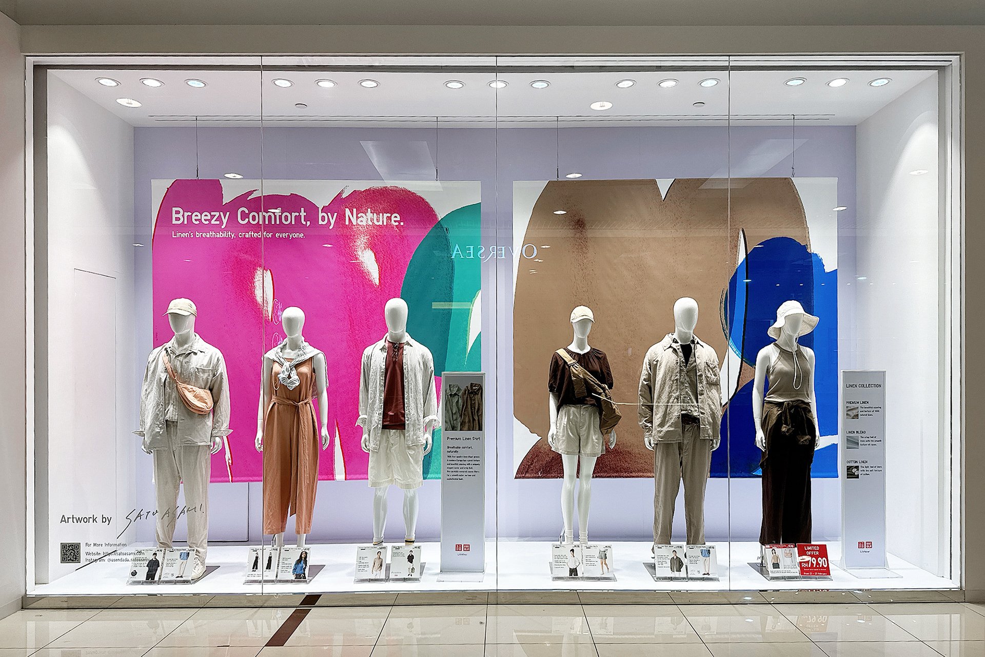 マレーシアのUNIQLO店舗にて展開された、サトウアサミのアートを背景にした春夏リネンコレクションのウィンドウディスプレイ。Spring/Summer window display at UNIQLO Malaysia featuring linen styling and colorful abstract artwork by Asami Sato