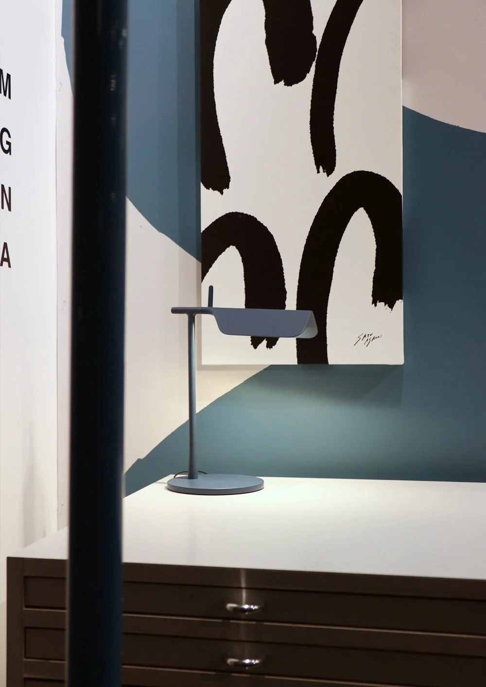 サトウアサミのdivision3シリーズの作品と、FLOSの照明が組み合わされた展示一角。Close-up of the division3 artwork by Asami Sato, paired with FLOS lighting in the exhibition space.