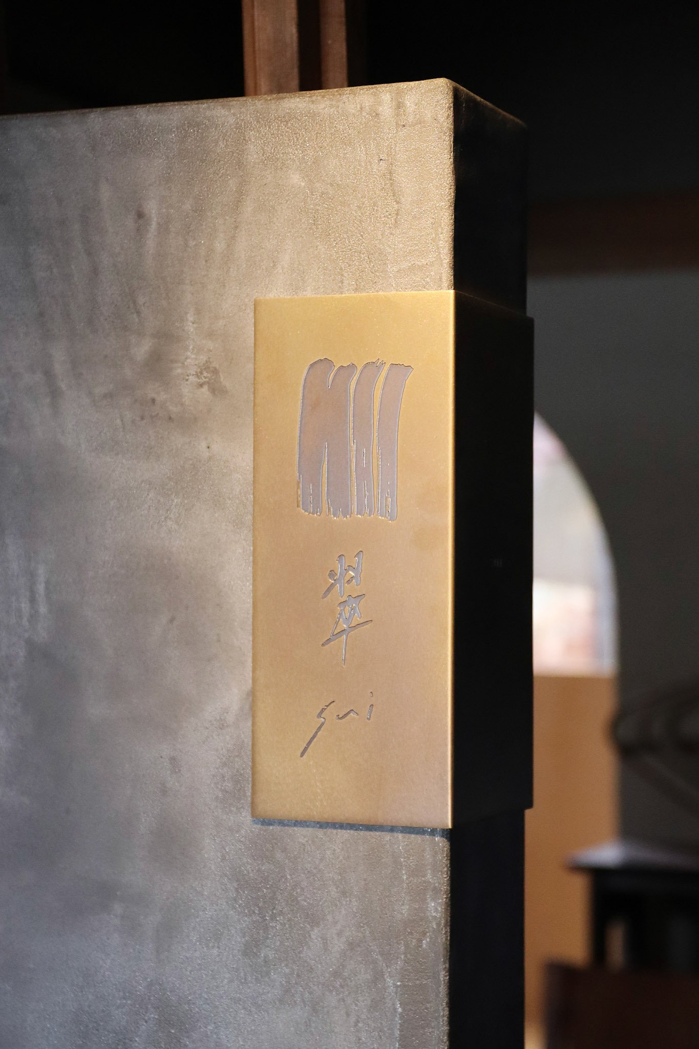 手描きの質感を活かしたロゴが印象的なサインプレート。「群青」のティールーム「翠 -sui-」のために設計され、素材と空間の対話を意識したデザインです。A signage plate designed for the tea room “Sui” at “Gunjo”, showcasing a logo with brushstroke textures that echo the serenity of the space and its materials.