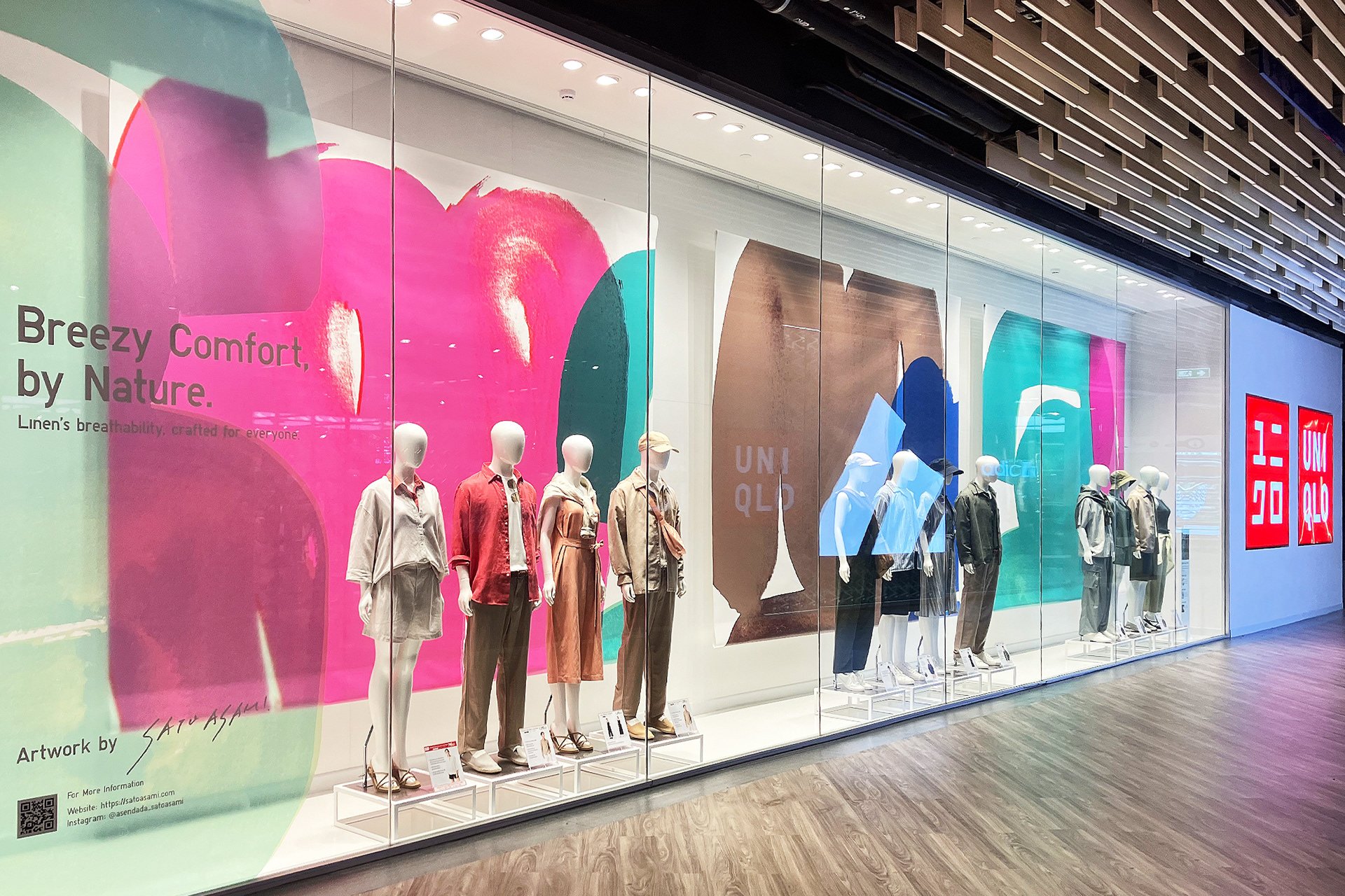 タイ・バンコクのUNIQLO店舗にて展開された、大型アートビジュアルと春夏リネンコレクションのディスプレイ(サトウアサミ作)UNIQLO Bangkok, Thailand: full-length storefront featuring Spring/Summer linen styles and large abstract visuals by Asami Sato