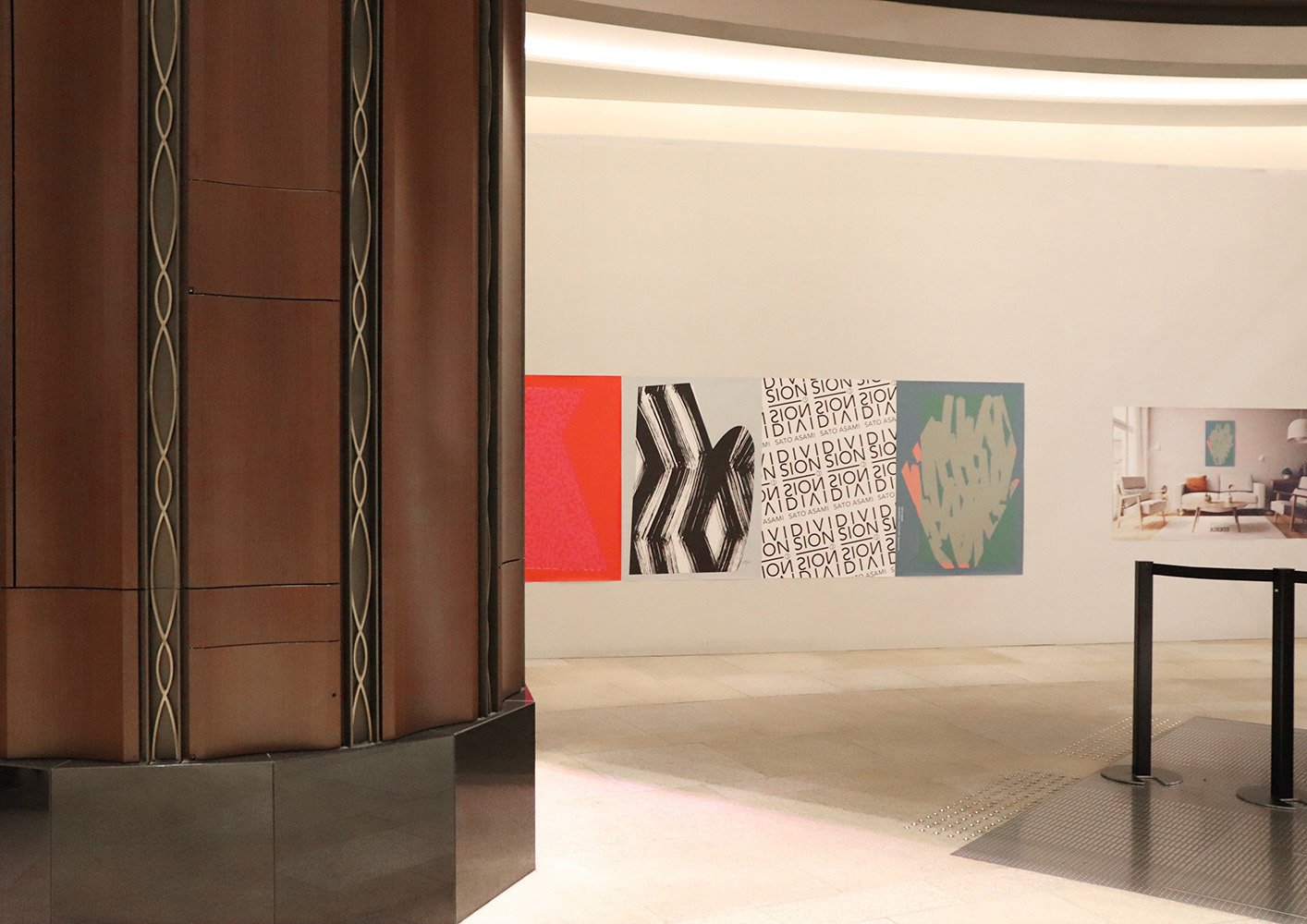 色彩や筆致の異なるSATO ASAMIのアート作品を並べた「DIVISION」シリーズの展示。多様な表現が壁面を構成している。A lineup of diverse pieces from SATO ASAMI’s “DIVISION” series, showcasing varied color palettes and brush expressions in a unified wall display.