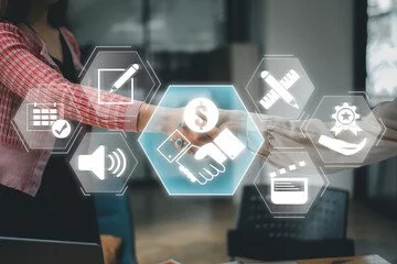 Businesswoman with a red checkered shirt and black vest interacting with a virtual digital interface displaying icons related to finance, communication, and technology.