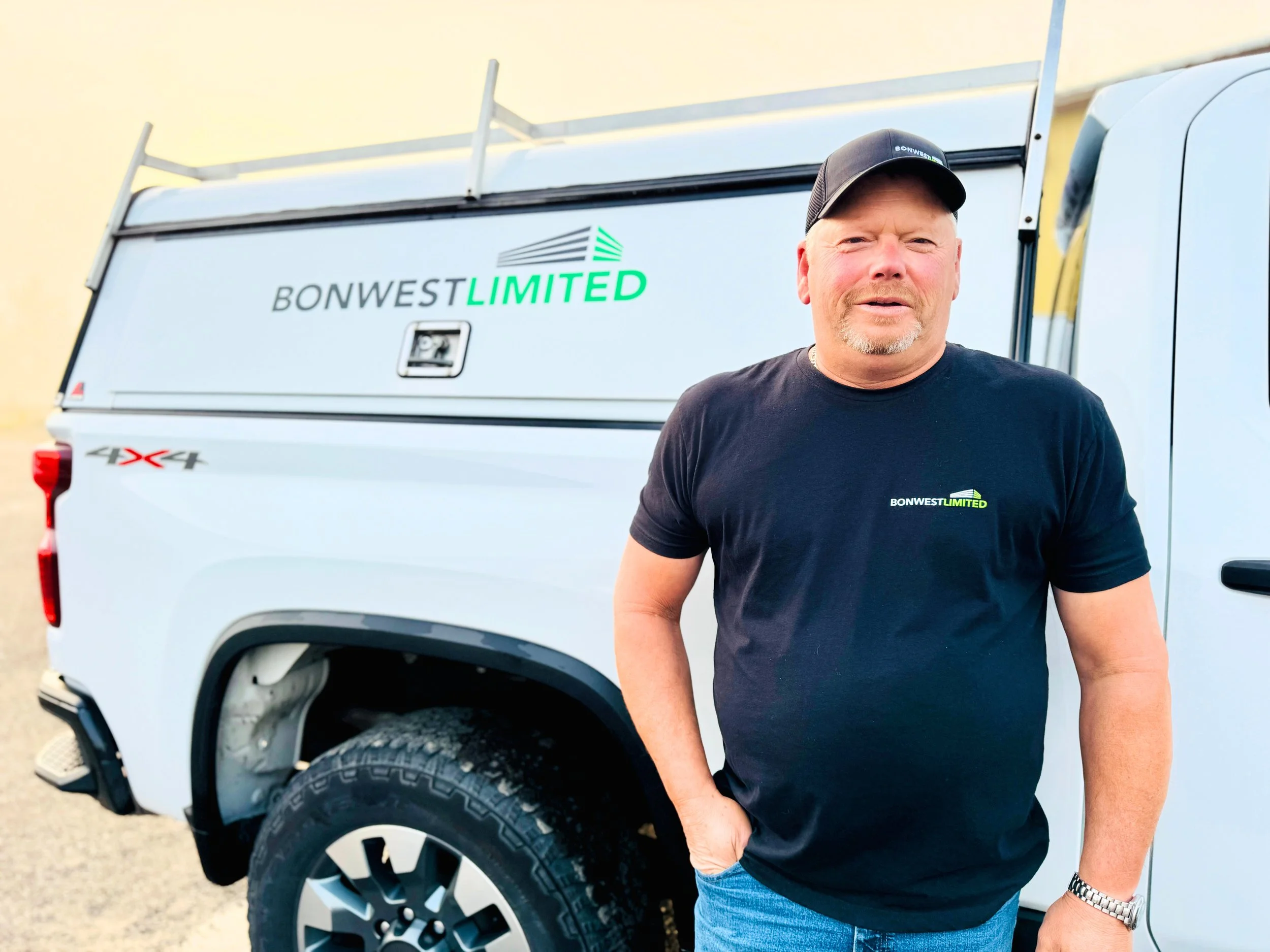 Man standing outdoors next to a white company truck with the logo "Bonwest Limited".