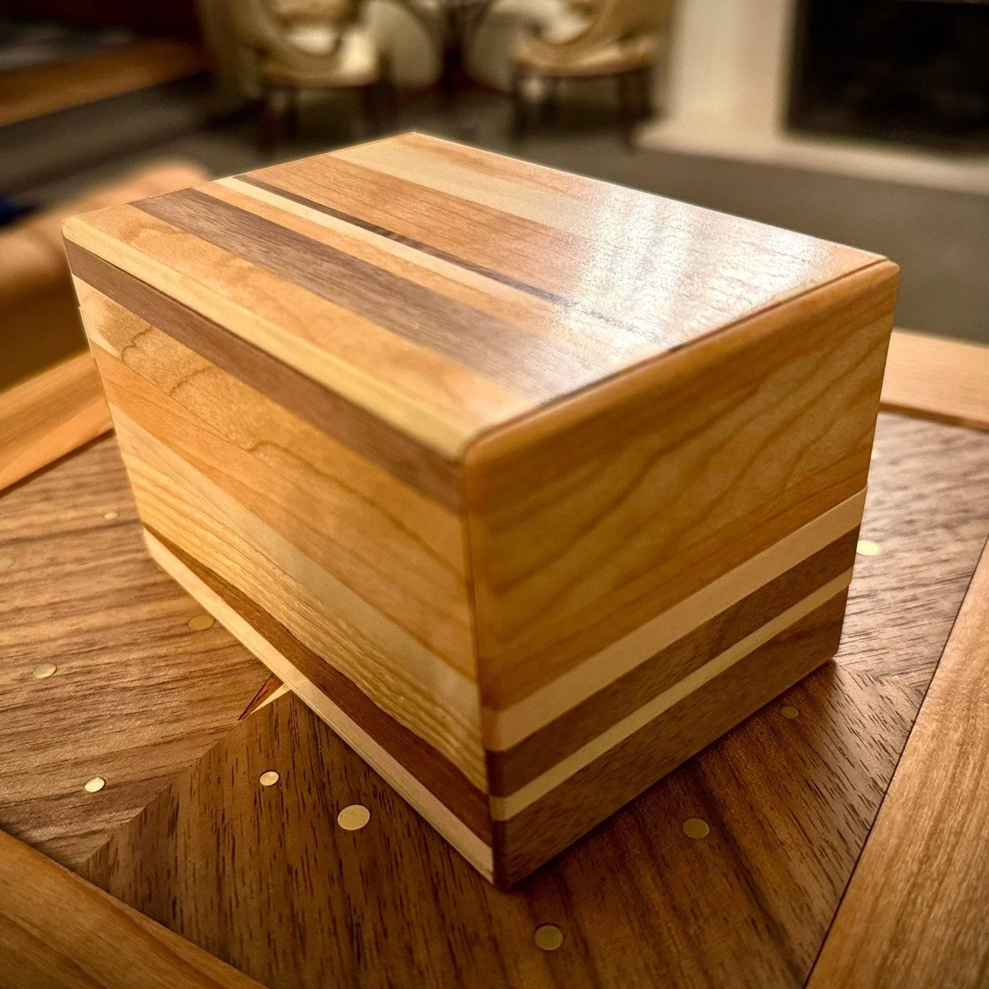 The Calico box. I wanted to experiment with using semi-random arrangements of wood species in order to hide sliding keys. Made from Cherry, Walnut, Maple, Ash, and Poplar. 19 moves to open.