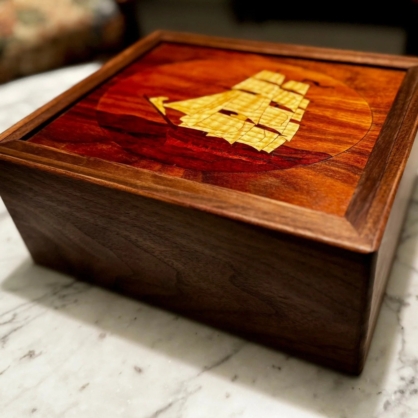 The Sinking Shop Box. This was a one-off box that I created to thematically fit some marquetry I had done. The box is an N-ary puzzle and takes somewhere around 40 moves to open.

I created a poem to narrate the solution:

The Ballad of the Founderin