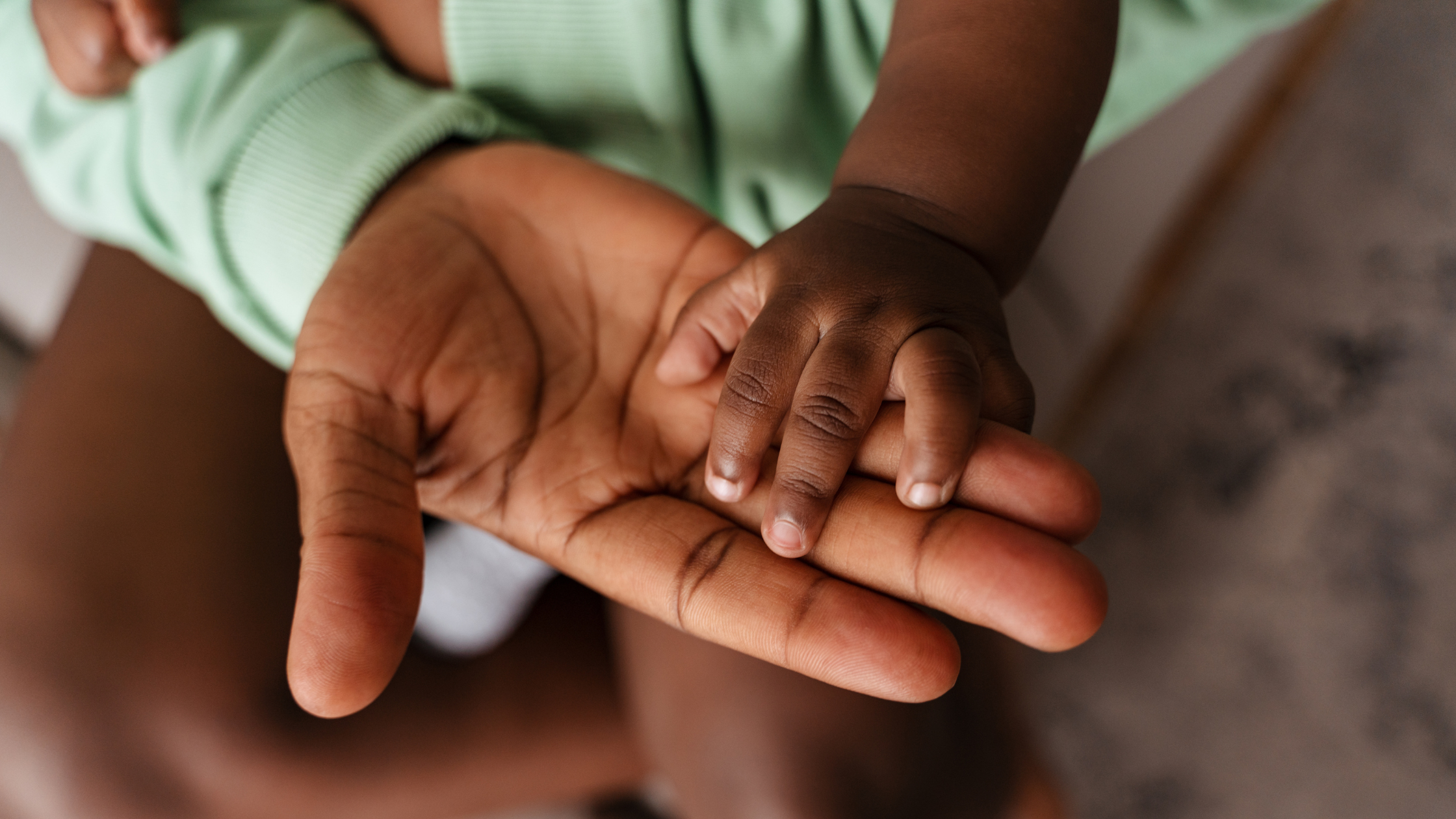close up of mom and baby's hand touching