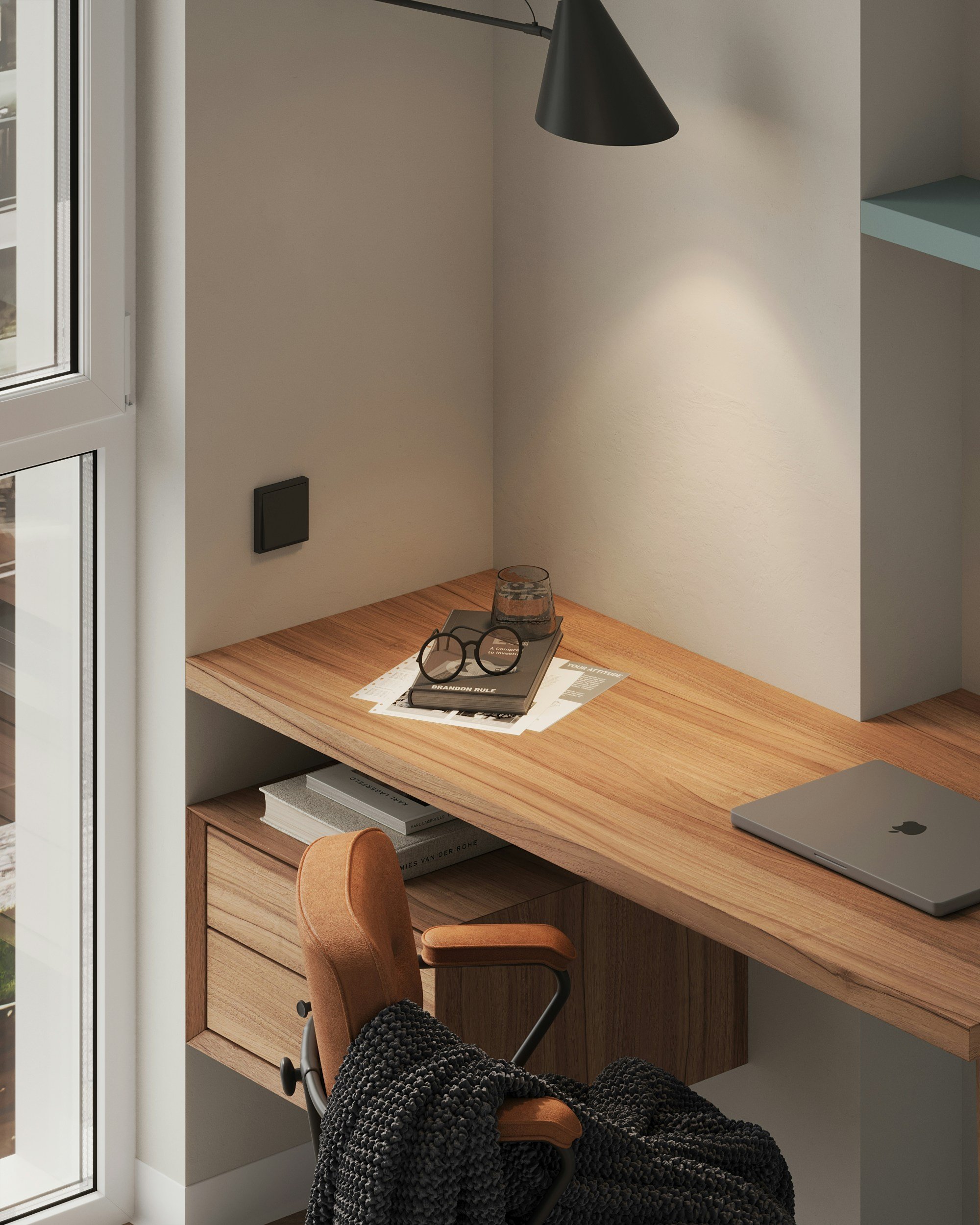 Modern workspace with a wooden desk, an orange chair, a laptop, glasses, a book, and a black textured blanket in a cozy corner near a window and a wall-mounted lamp.