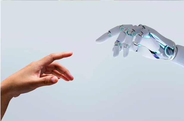 A human hand reaching towards a robotic hand against a plain background.