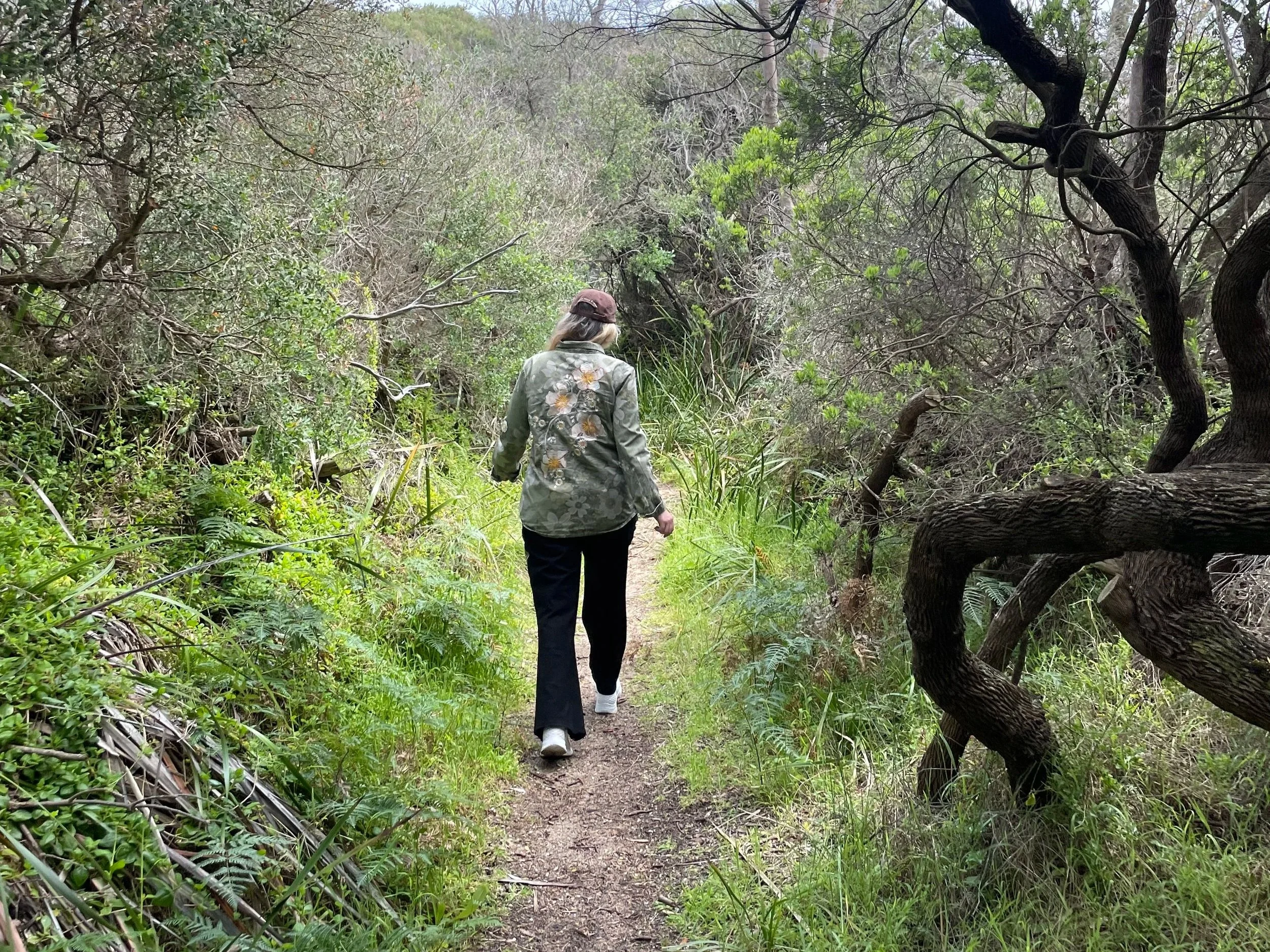 woman walking through long grass