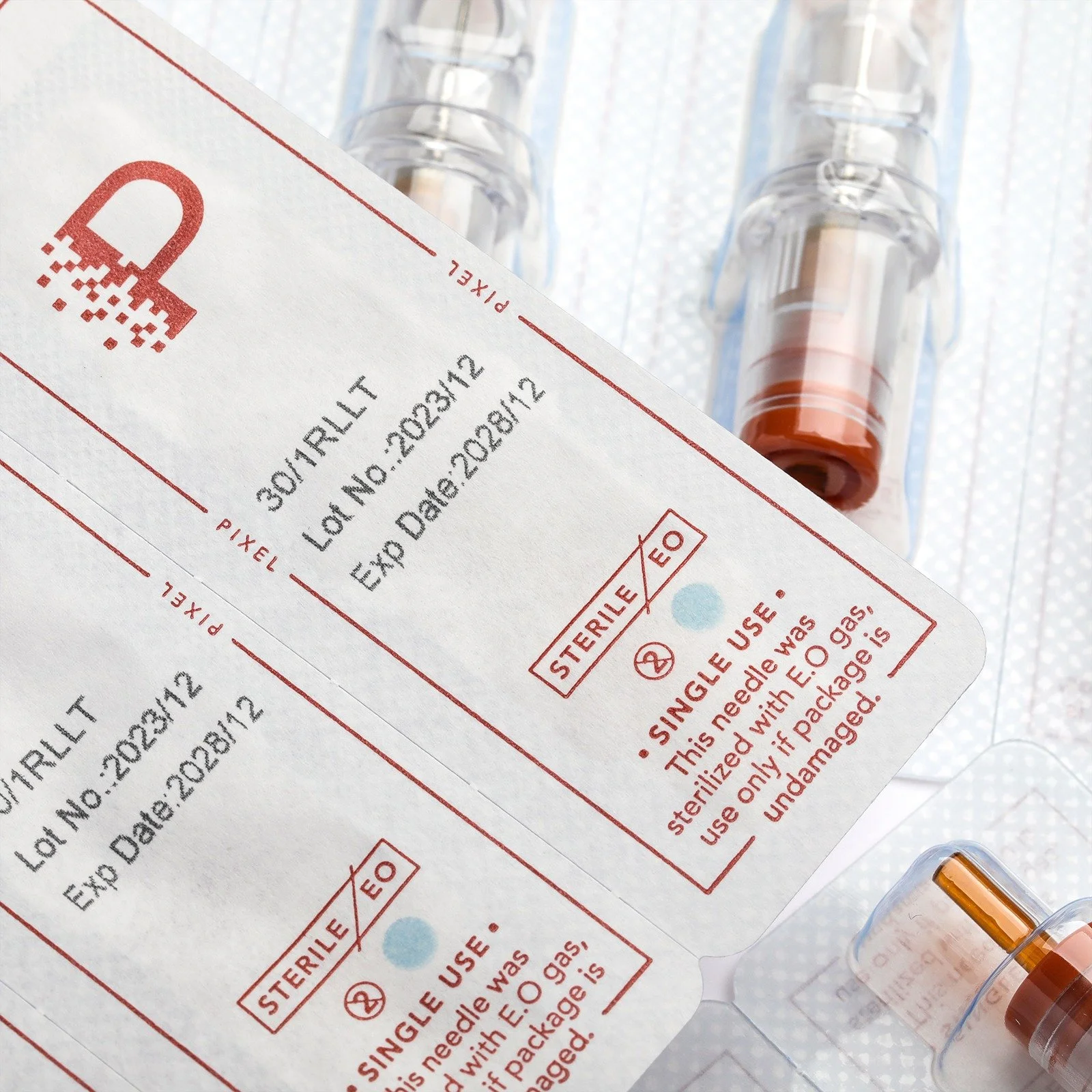 Medical syringes filled with orange liquid and sterile labeling indicating single use and expiration date.