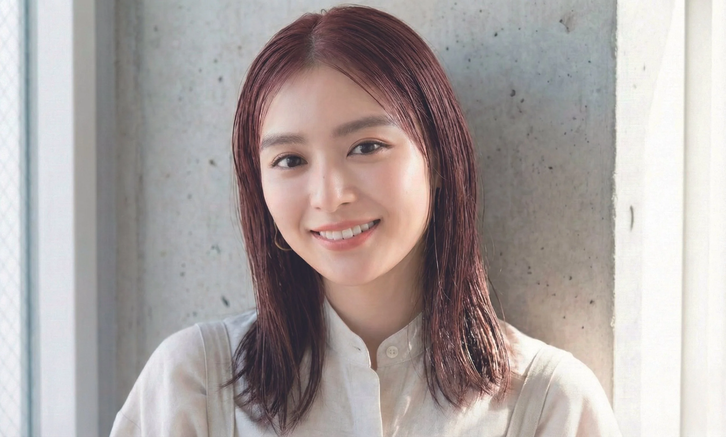 笑顔の若い女性、白い壁の前