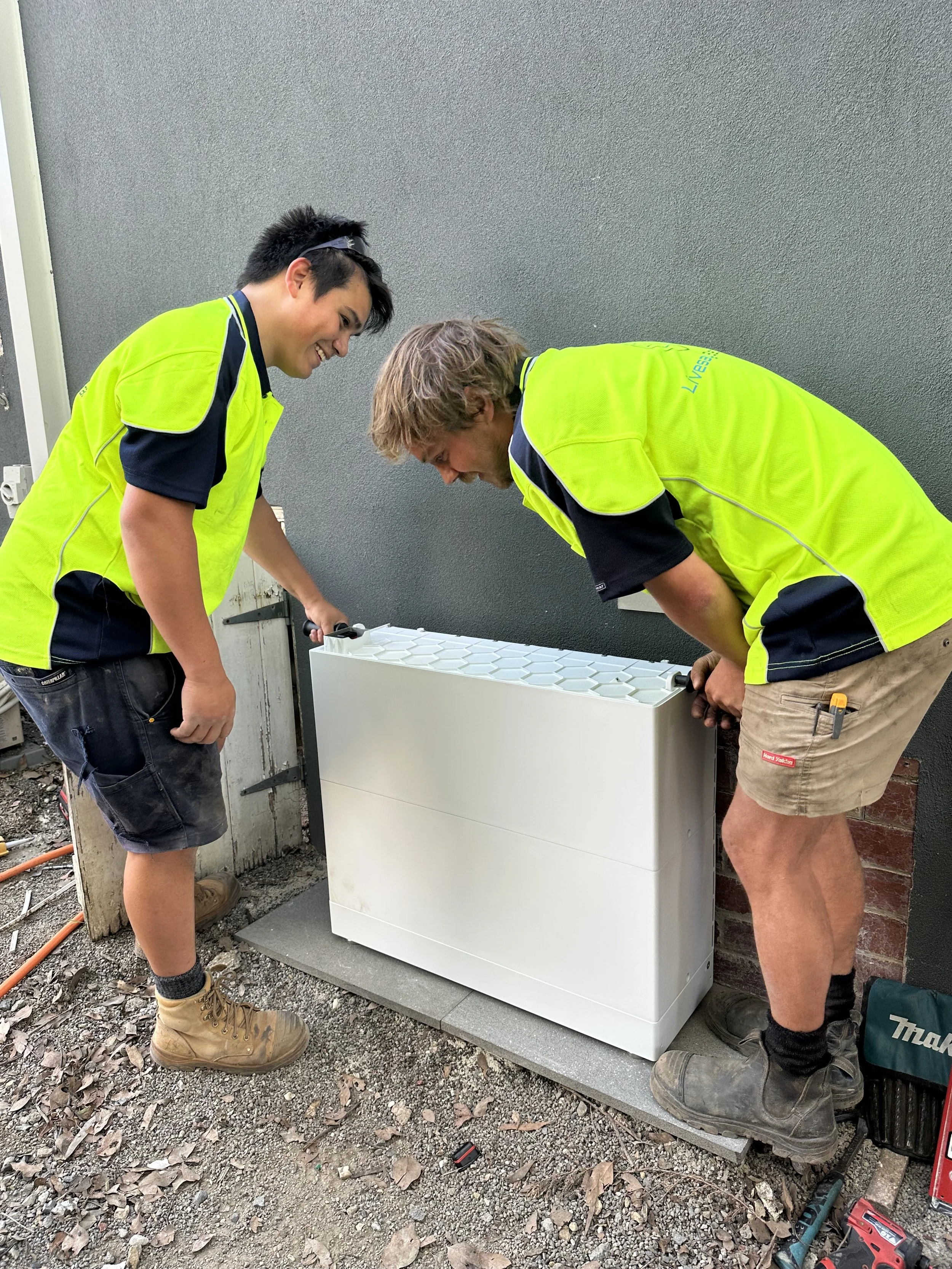 Two electricians installing a solar battery in Melbourne