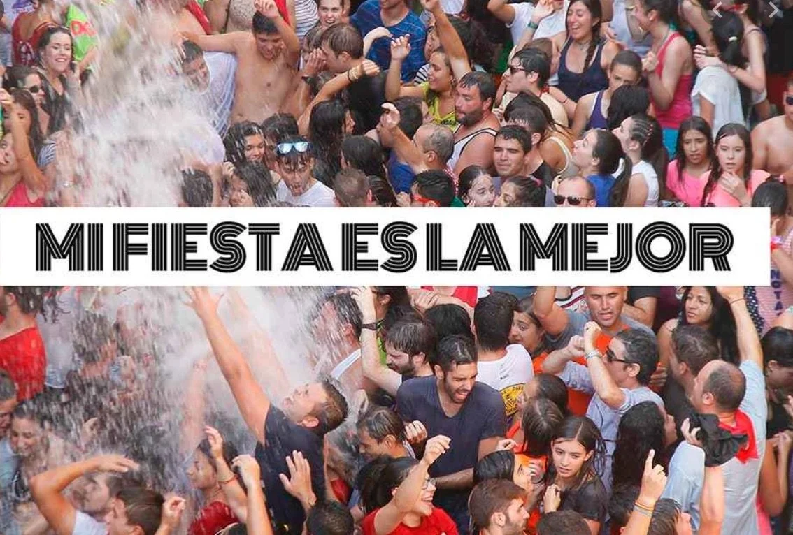 Una multitud de personas en una fiesta, algunas mojadas y bailando, celebrando con alegría.
