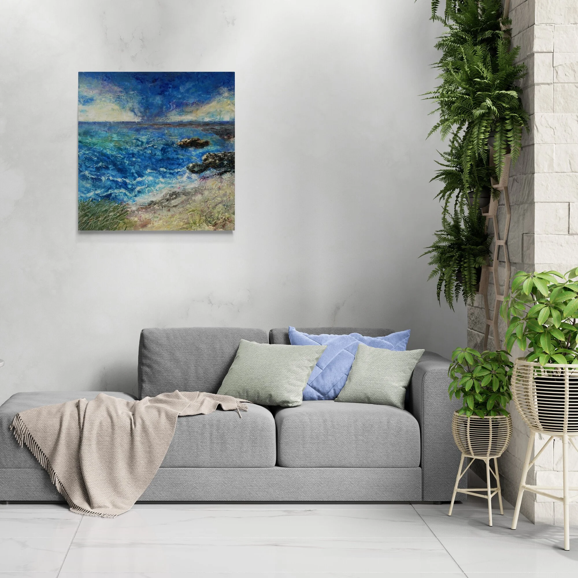 Interior view with Dora Stork’s “Tidal Soul” displayed above a modern sofa, highlighting its vibrant blue seascape and textured encaustic surface.
