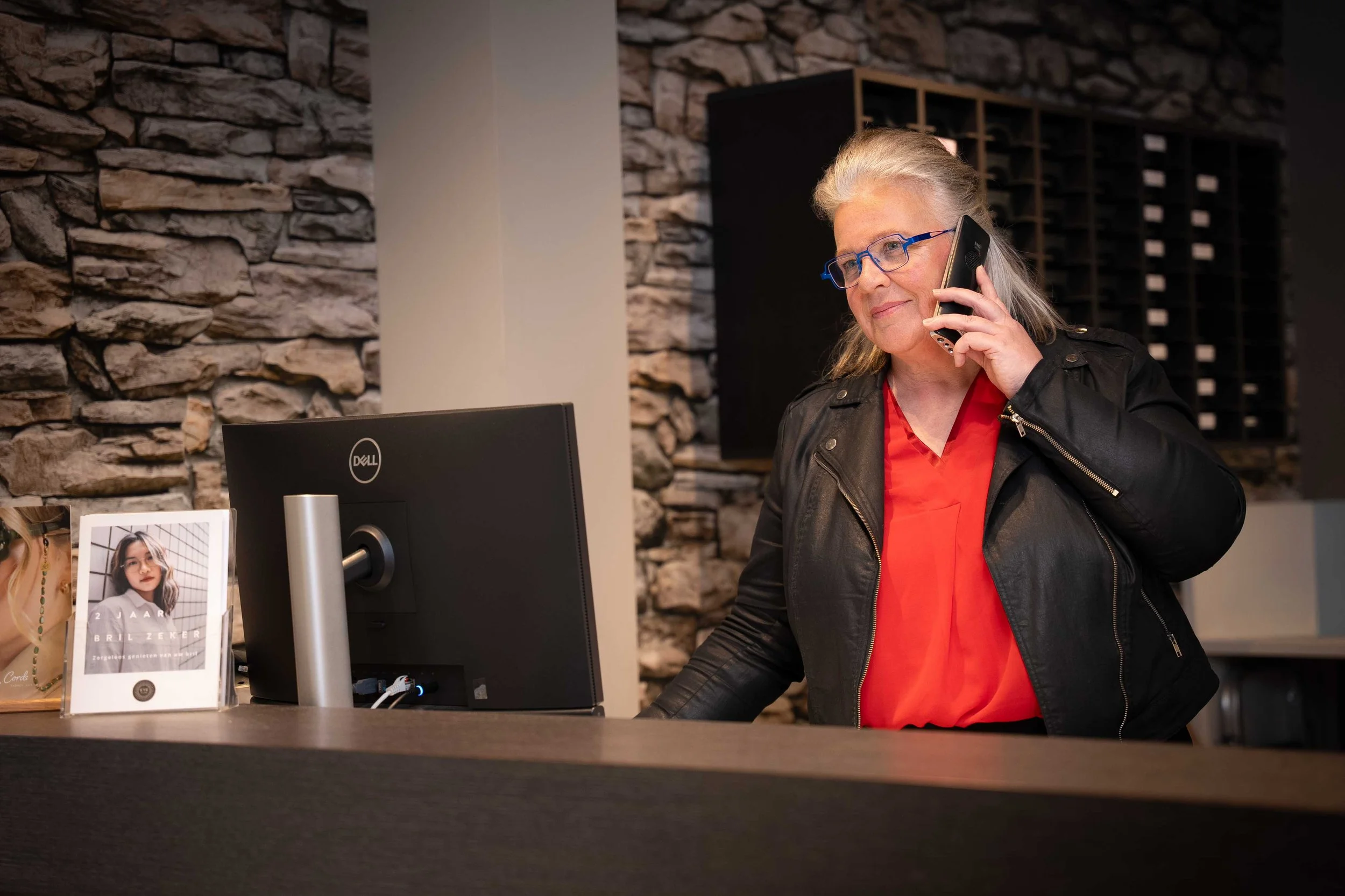 Vrouw aan telefoon in optiekwinkel tijdens bedrijfsfoto's in winkel voor EyeCare door Studio Brenda bedrijfsfotografie