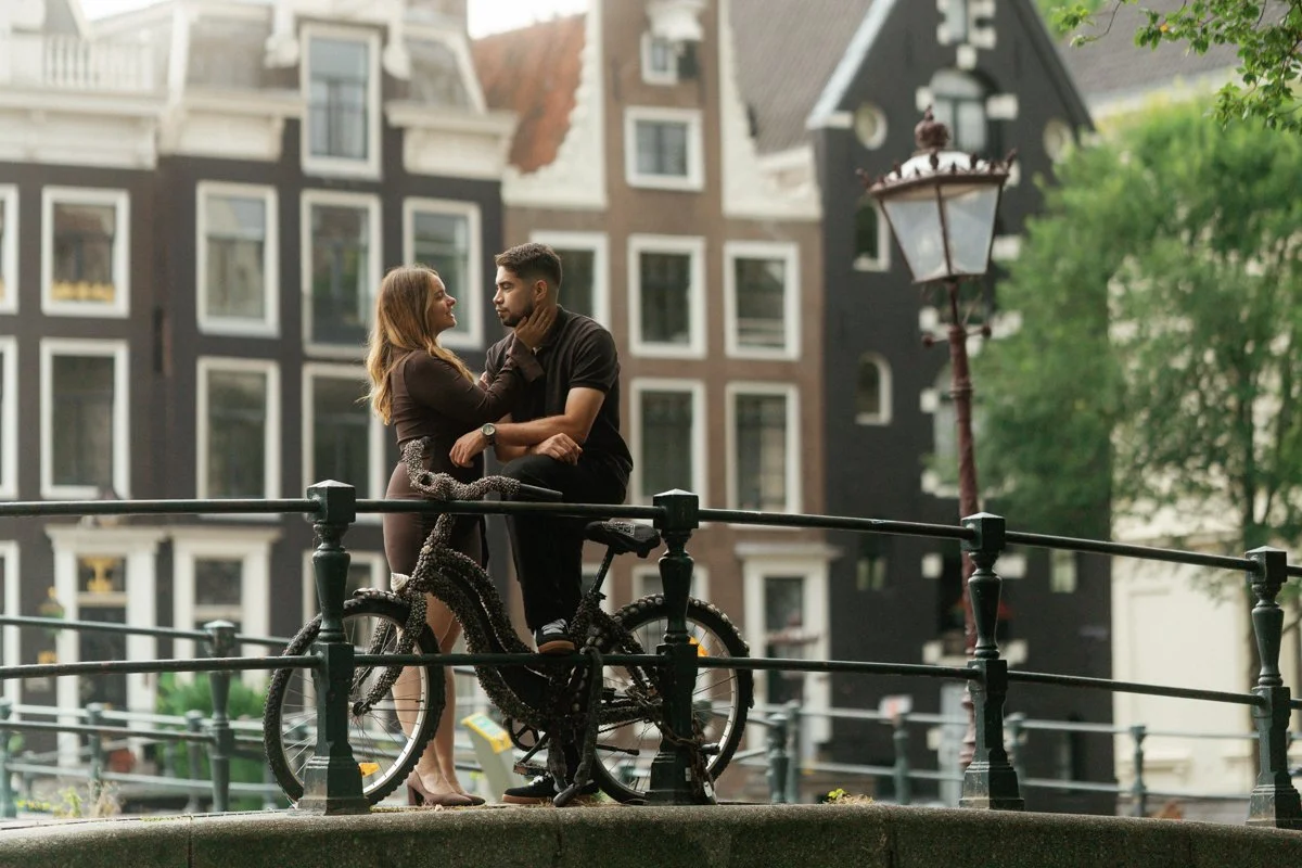 A couple on a bridge by the Amsterdam canals sharing romantic time together
