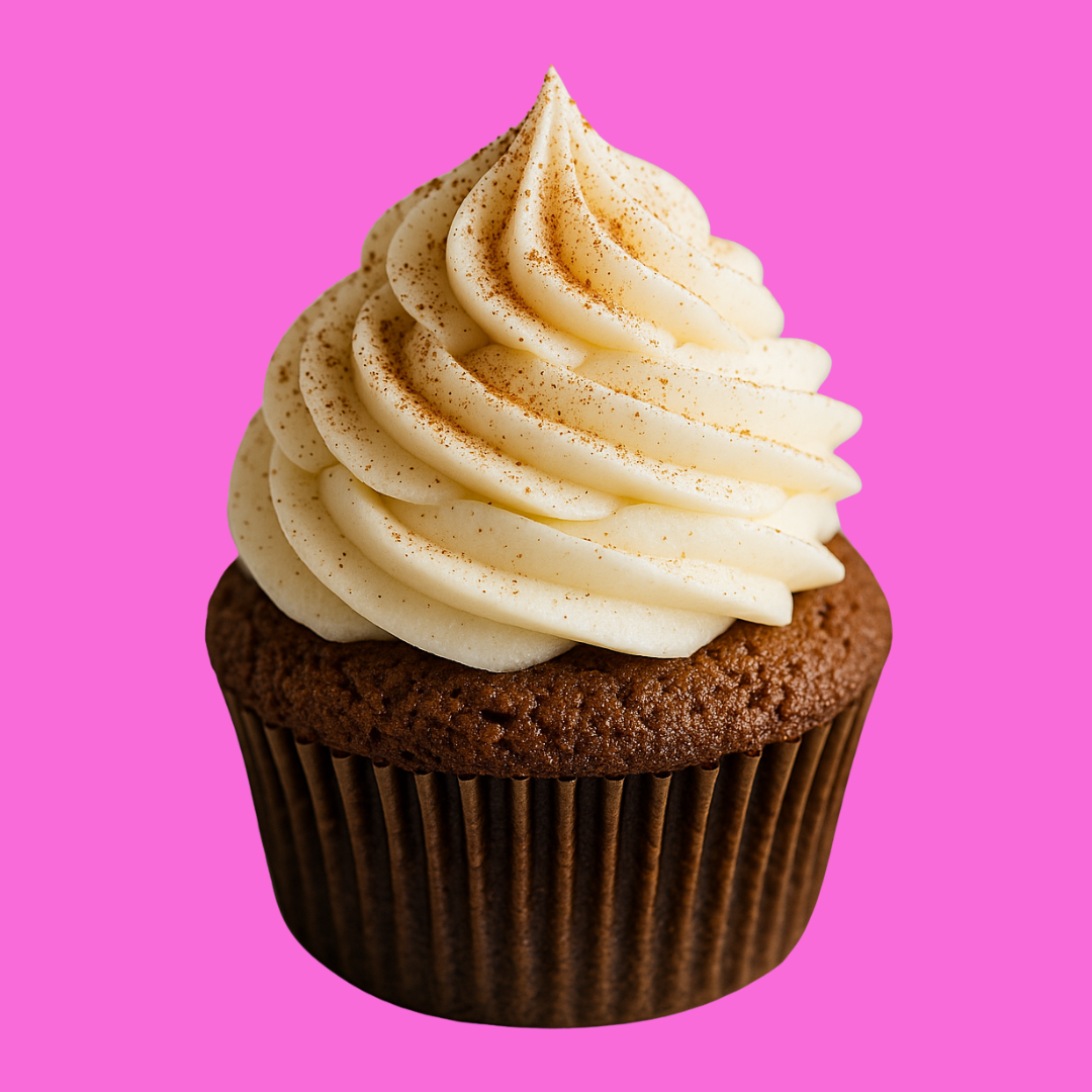 Chocolate cupcake with swirled vanilla frosting sprinkled with cinnamon against a pink background.