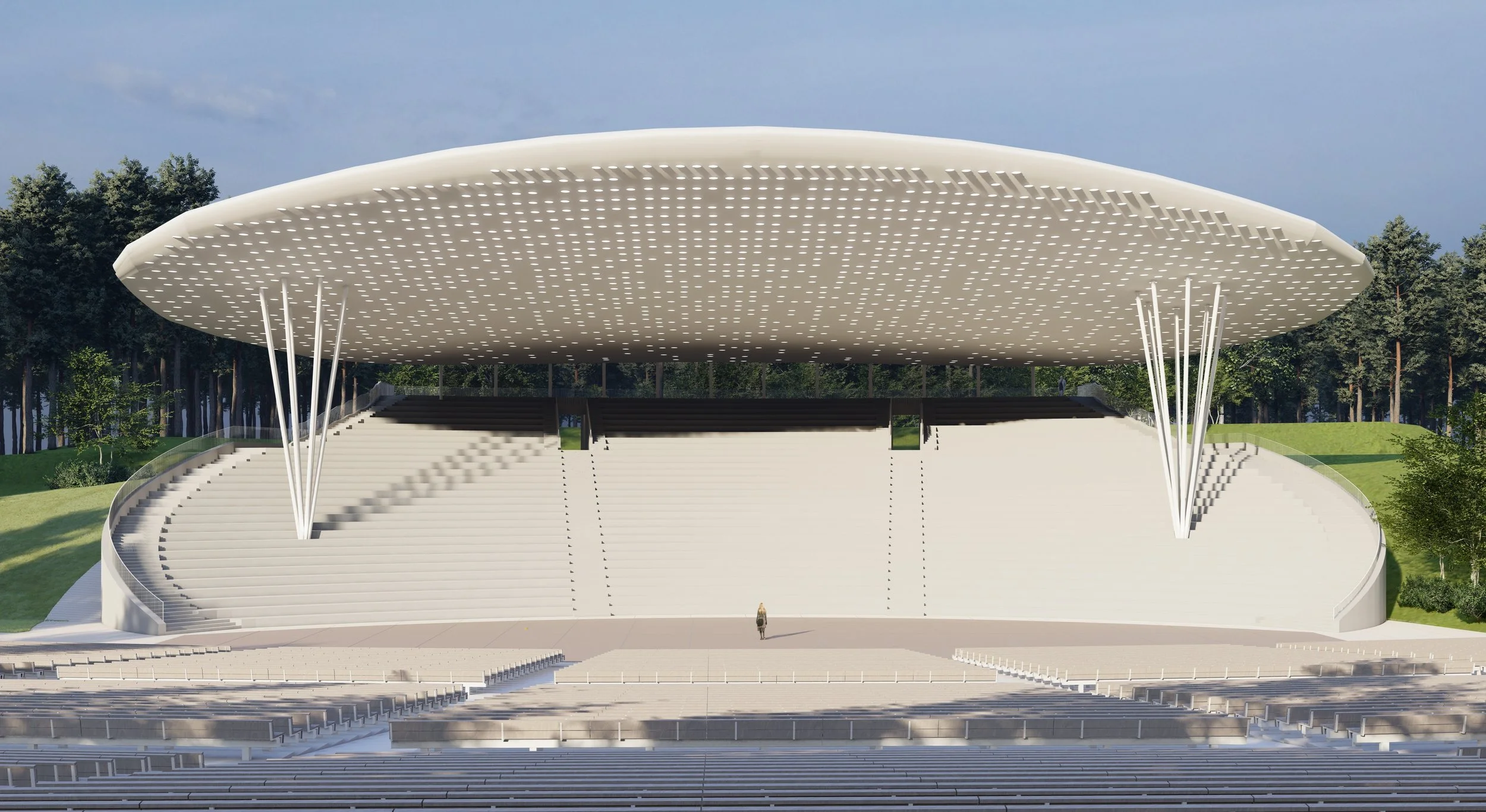 Modern outdoor amphitheater with white tiered seating and a large, curved roof supported by thin white columns, surrounded by trees.