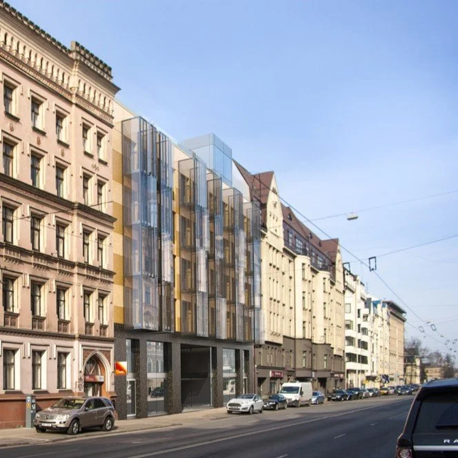 City street with a mix of historic and modern buildings, parked cars, and overhead tram lines.