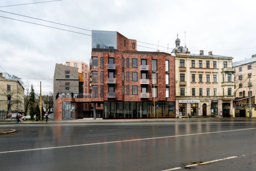 Modern mixed-use building with brick facade on a city street, adjacent to older historic buildings, under cloudy sky.