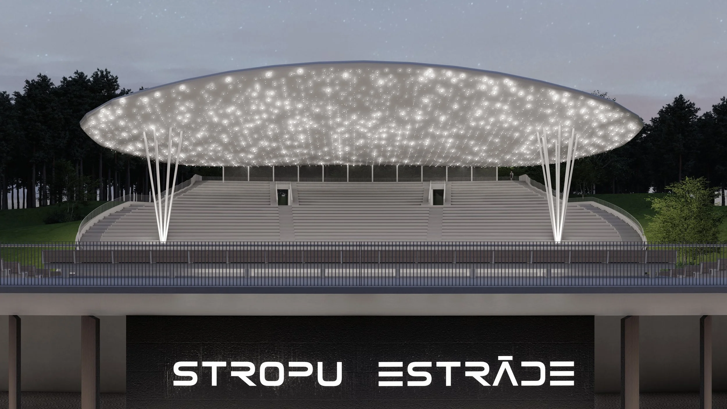 Night view of a modern outdoor amphitheater with a large illuminated canopy supported by white columns, and the words 'Stropu Estrāde' on the front.