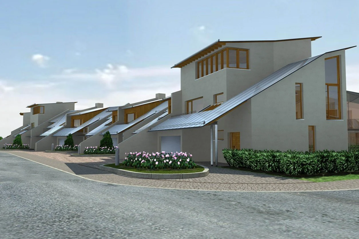 A row of modern, multi-story houses with unique sloped roofs and wooden framing, surrounded by landscaped bushes and flowers on a paved street.