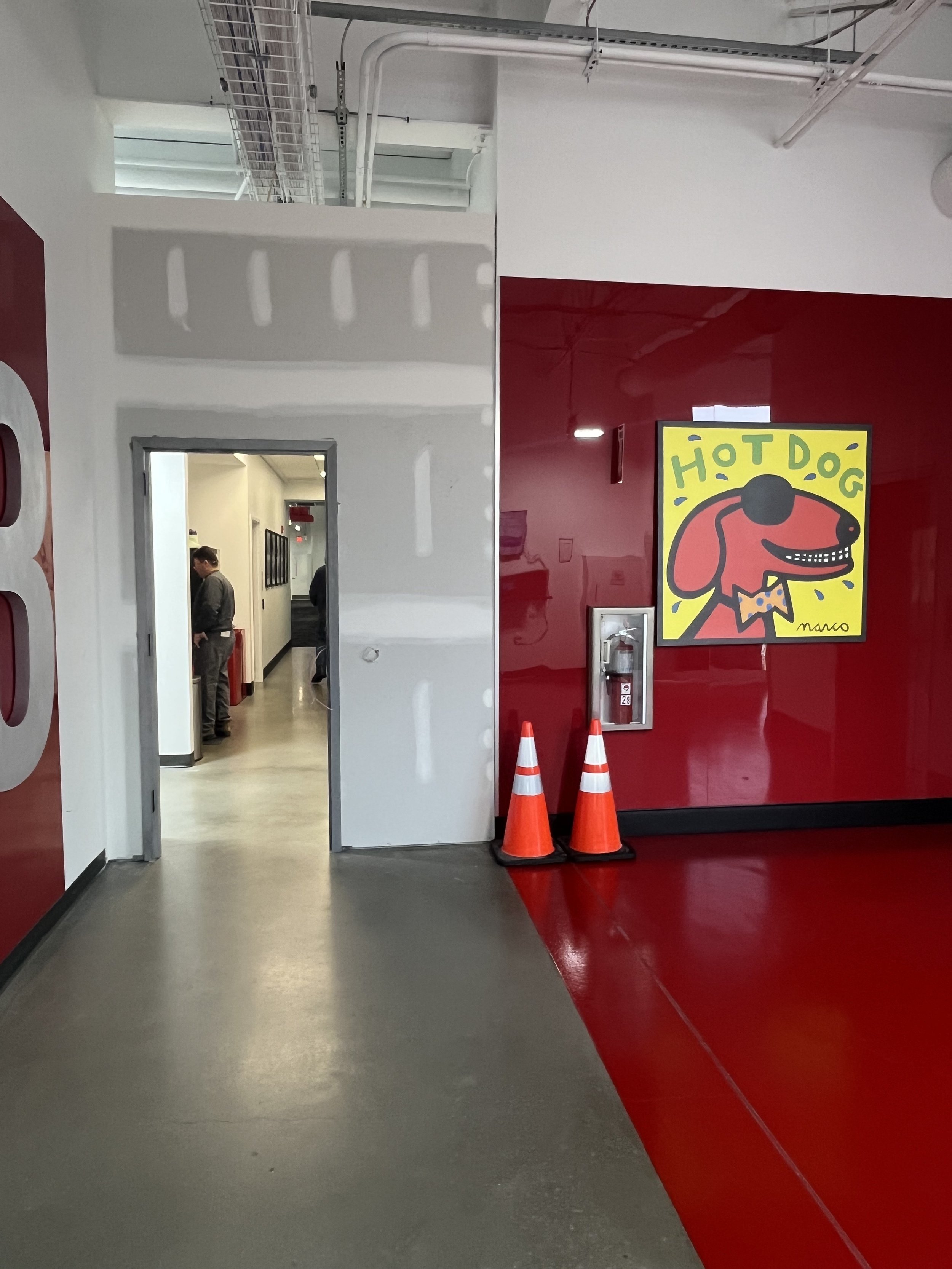 Third-floor commercial corridor showing a secure access door installation at Thorlabs, featuring fresh drywall, industrial finishes, and safety signage. Demonstrates professional interior build-out quality and facility upgrade work