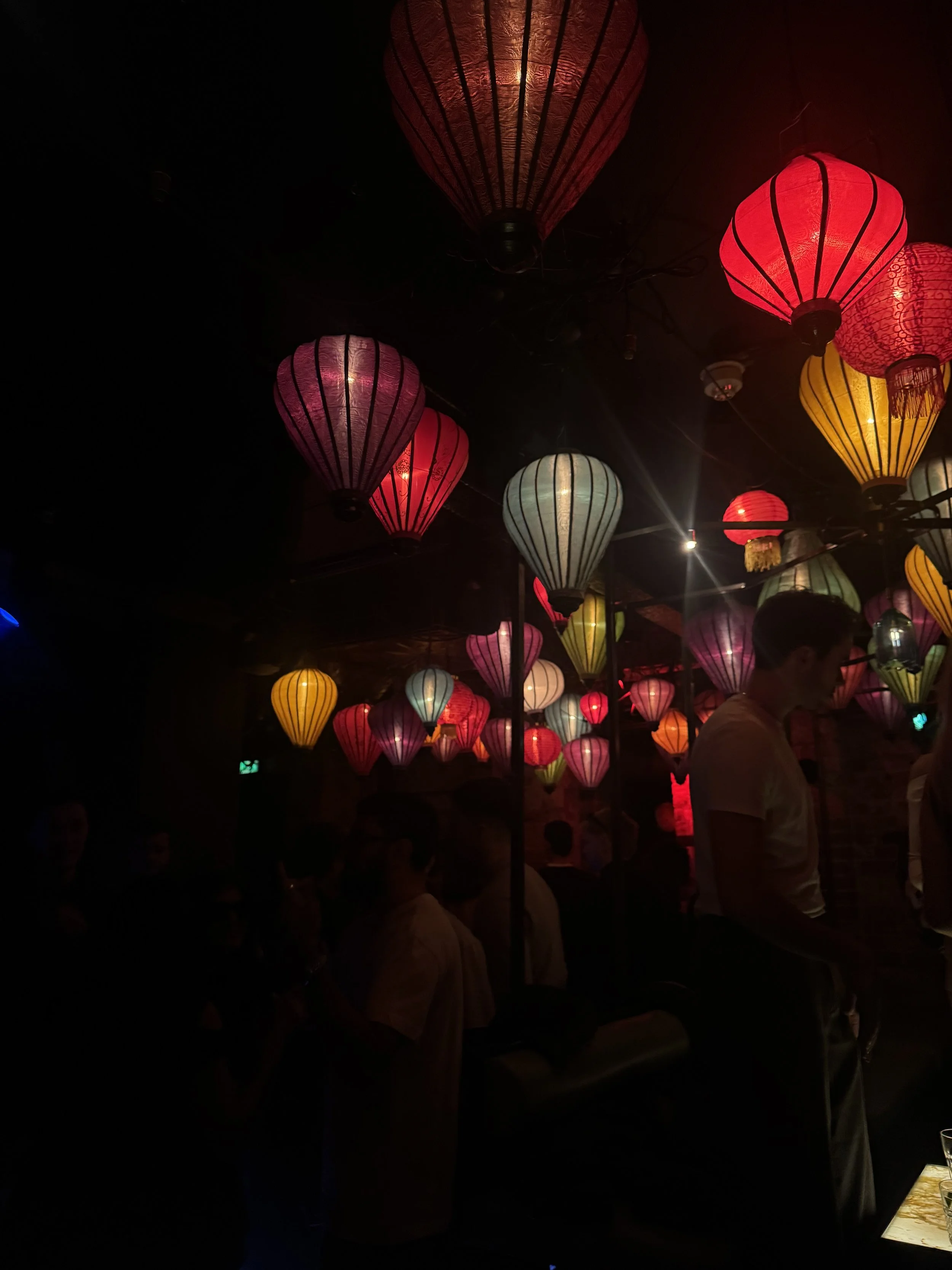 Atmospheric restaurant or event space with hanging lantern lighting and guests, captured for hospitality social media marketing and experiential branding.