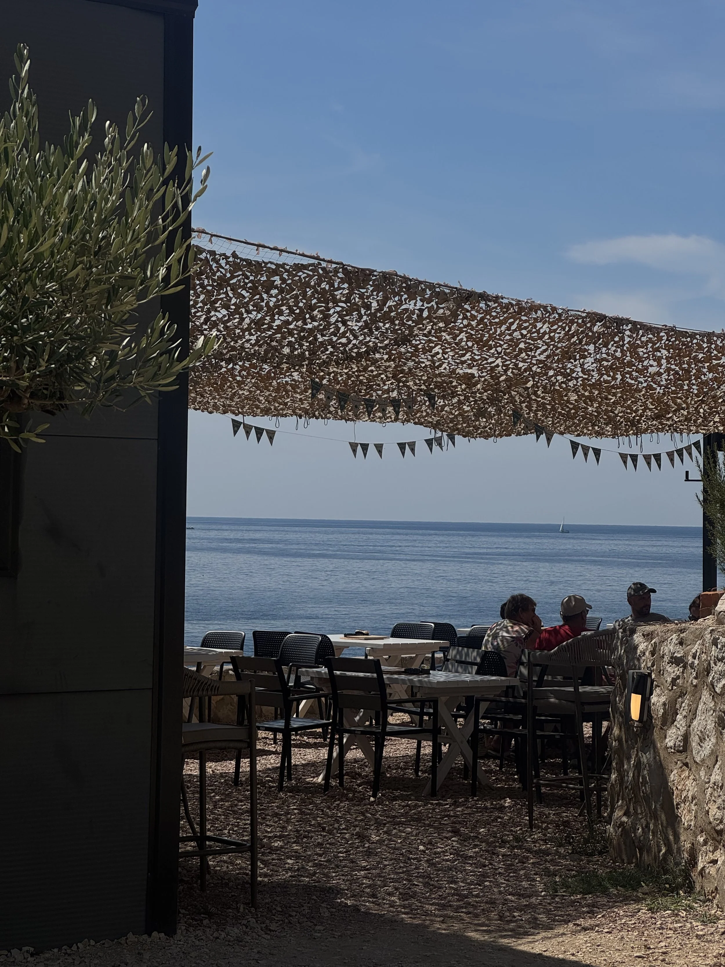Seaside restaurant terrace overlooking the ocean with relaxed dining setup, captured for travel and hospitality social media marketing content.