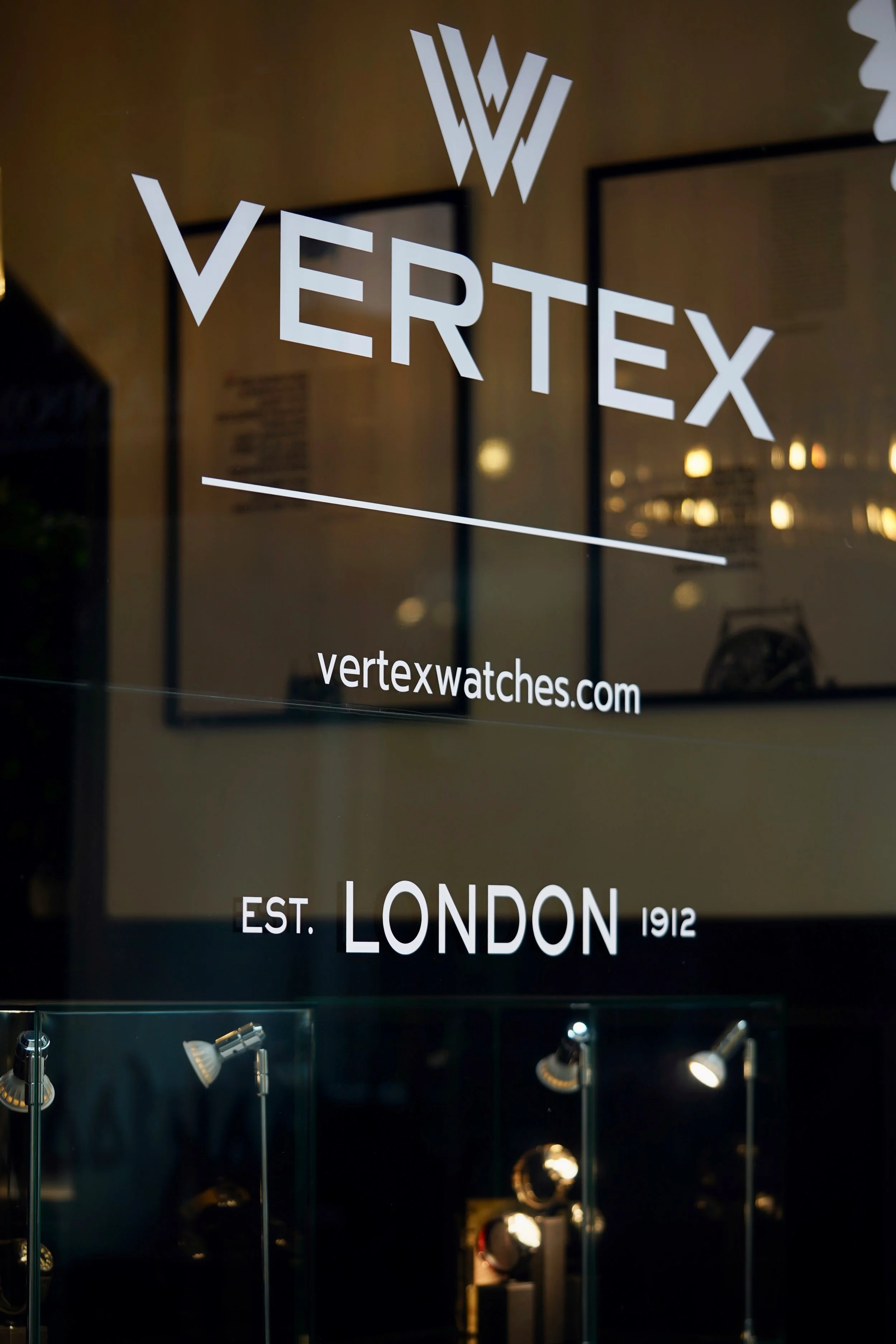 Glass display window with the logo and name of Vertex, a watch company, and the text 'Est. London 1912'.