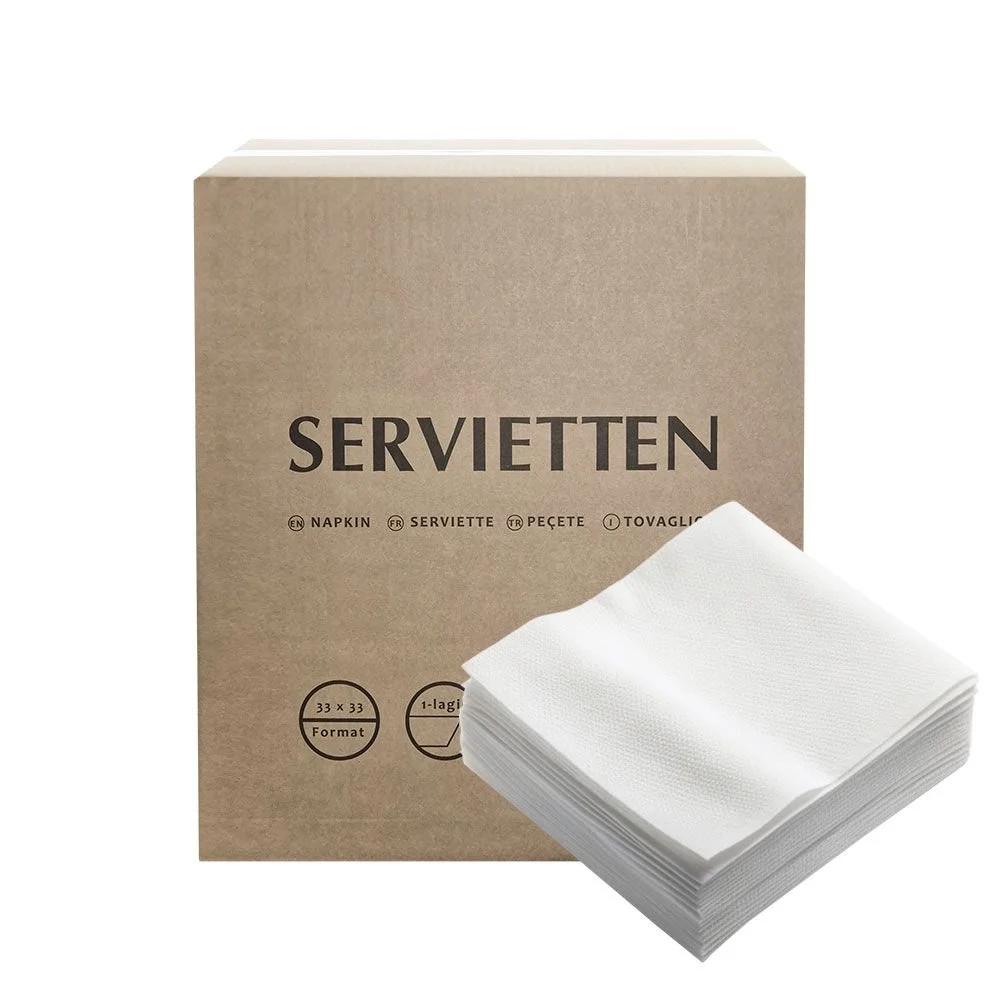 Ein Karton mit Papierservietten und mehreren Papierservietten davor