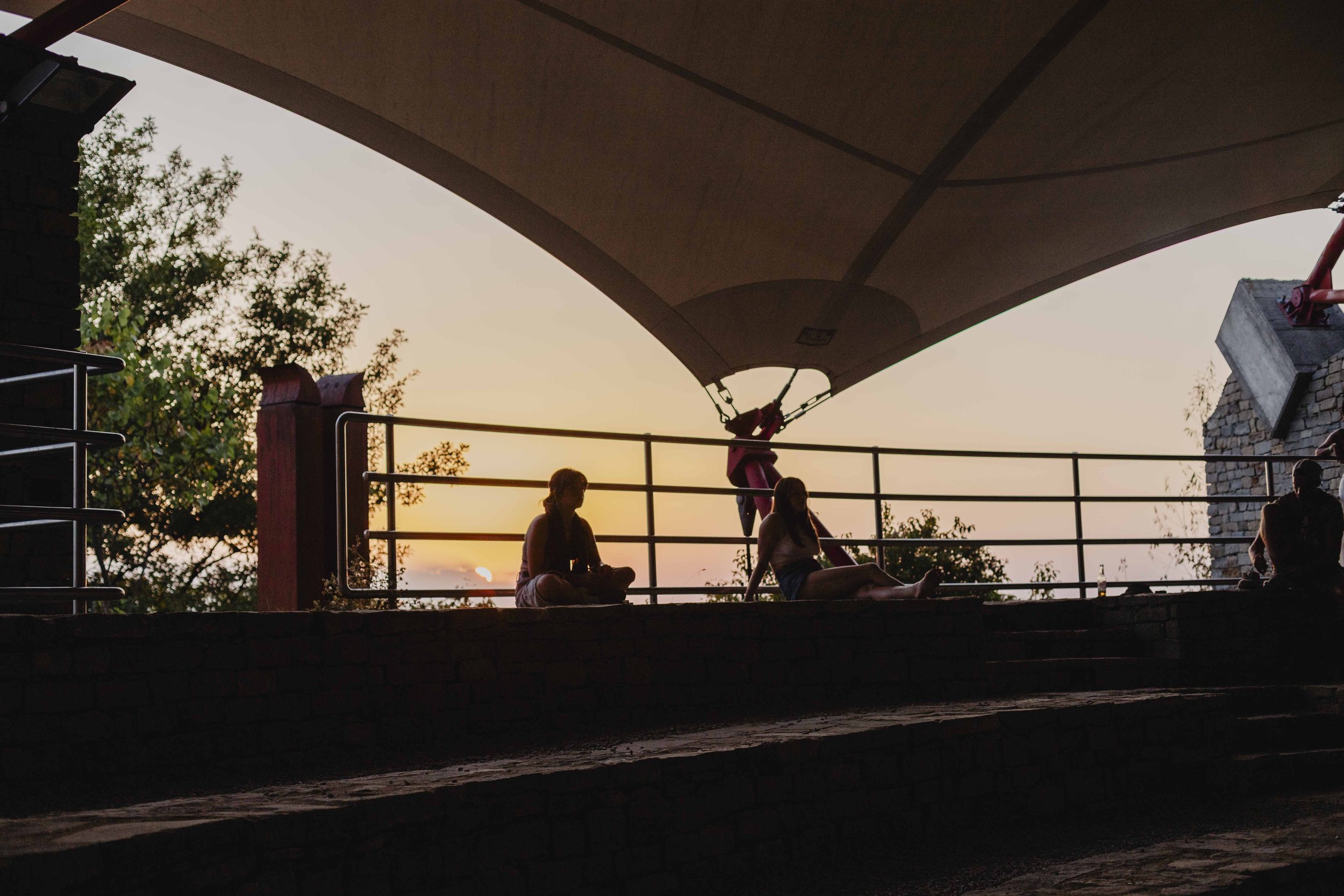 Persone sedute al tramonto nel Teatro della Pietra durante ECOFestival a Bergolo