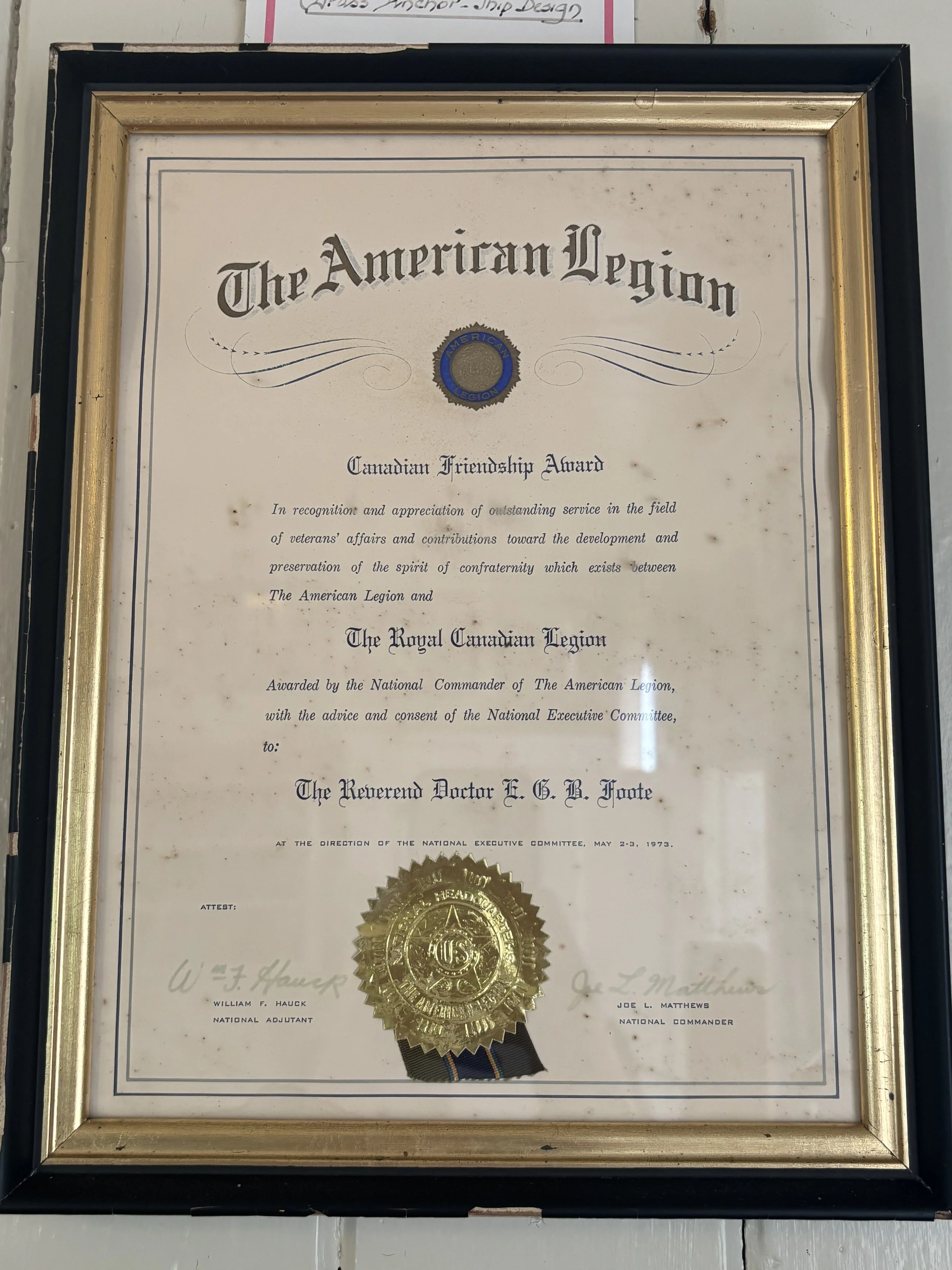 Framed certificate from The American Legion, Canadian Friendship Award, awarded to Reverend Doctor T. G. B. Foote, signed by William F. Hauck and Joe L. Matthews, with a gold seal and ribbon at the bottom.