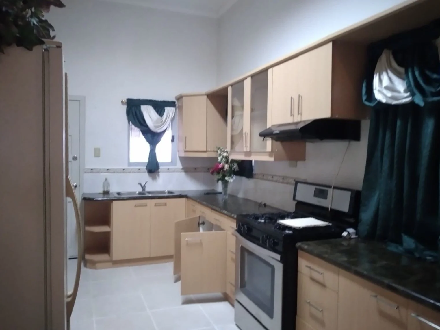 Main house kitchen with gas stove and oven. Custom cabinets with marble countertops.