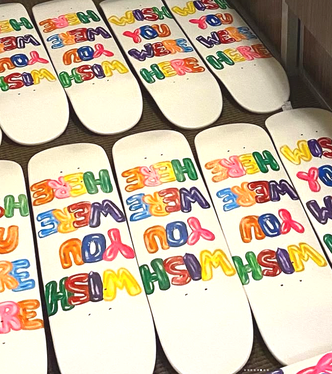 Multiple skateboards with colorful 'Welcome' and 'You' message painted on them.