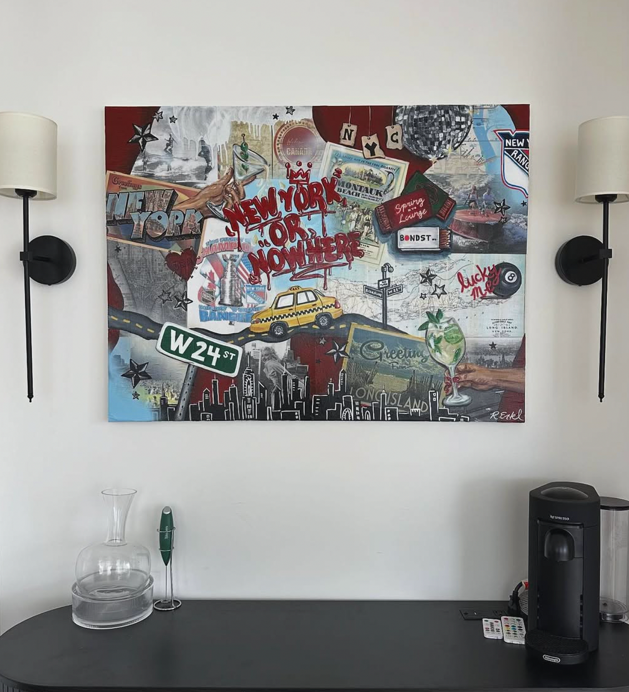 Decorative collage on wall featuring New York City landmarks, street signs, a taxi, a cocktail, and various travel-themed and New York-related images, with the phrase "New York or Nowhere" in the center.