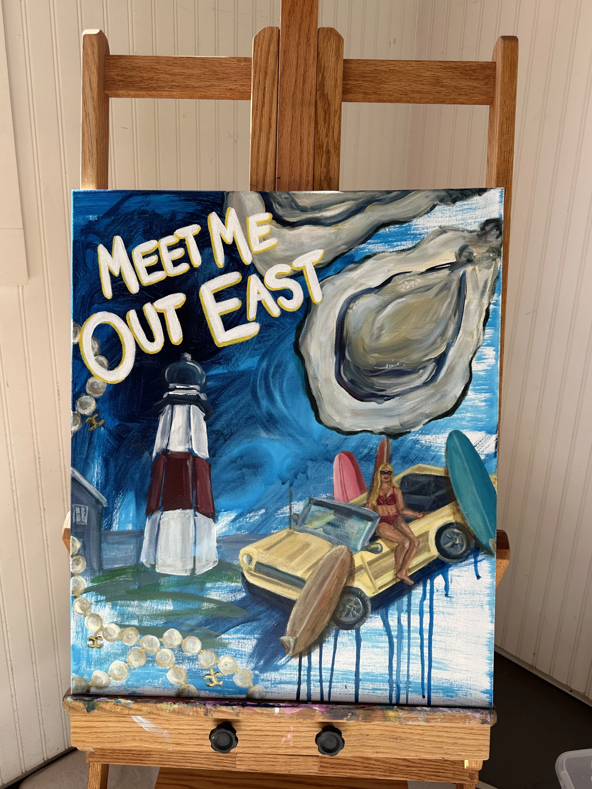A colorful painting on a canvas of a summer beach scene with the words 'Meet Me Out East' written in yellow letters. The scene includes a lighthouse, a woman in a swimsuit sitting on a car, surfboards, and a string of pearls.