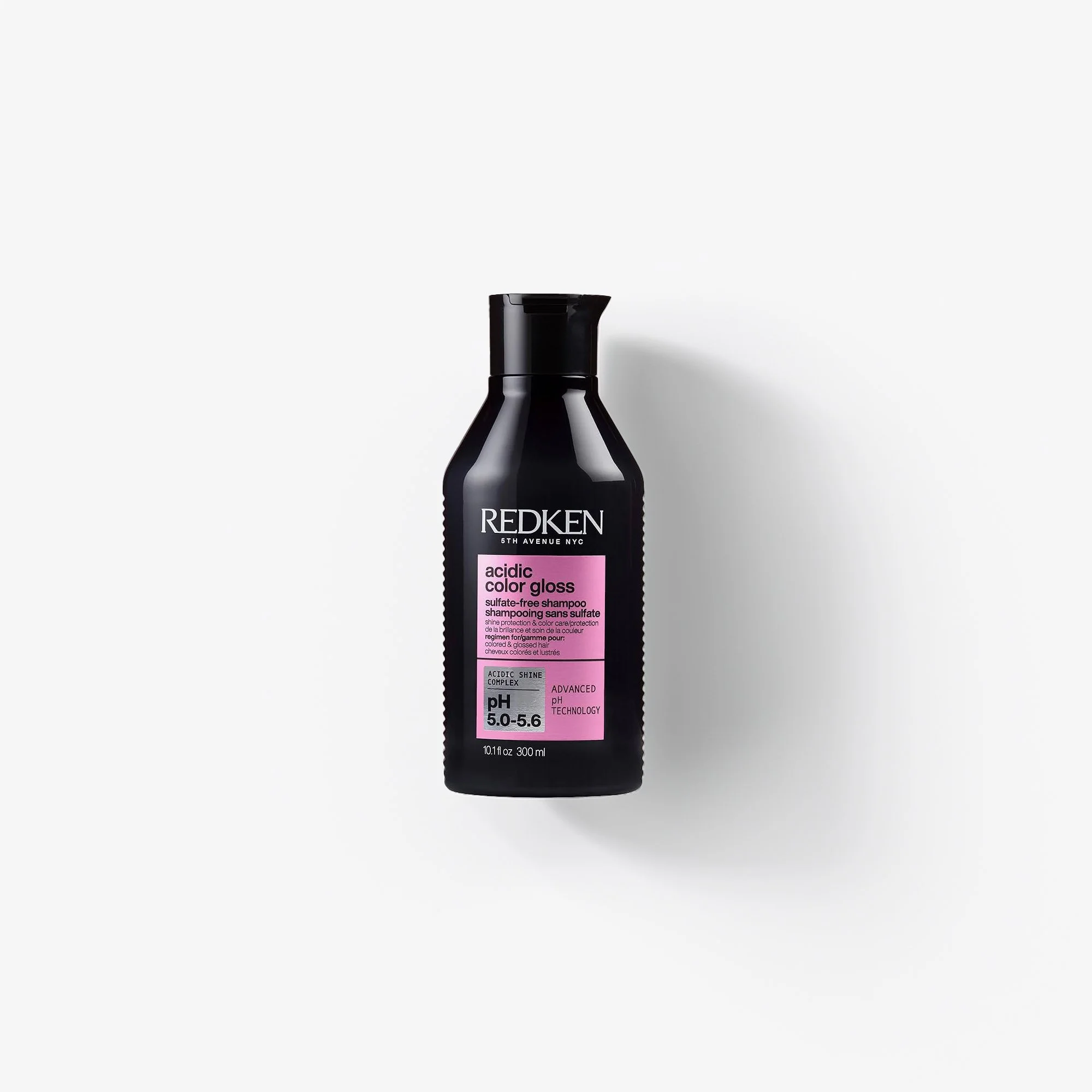 A black bottle of Redken Acidic Color Gloss shampoo with a pink label, placed against a plain white background.