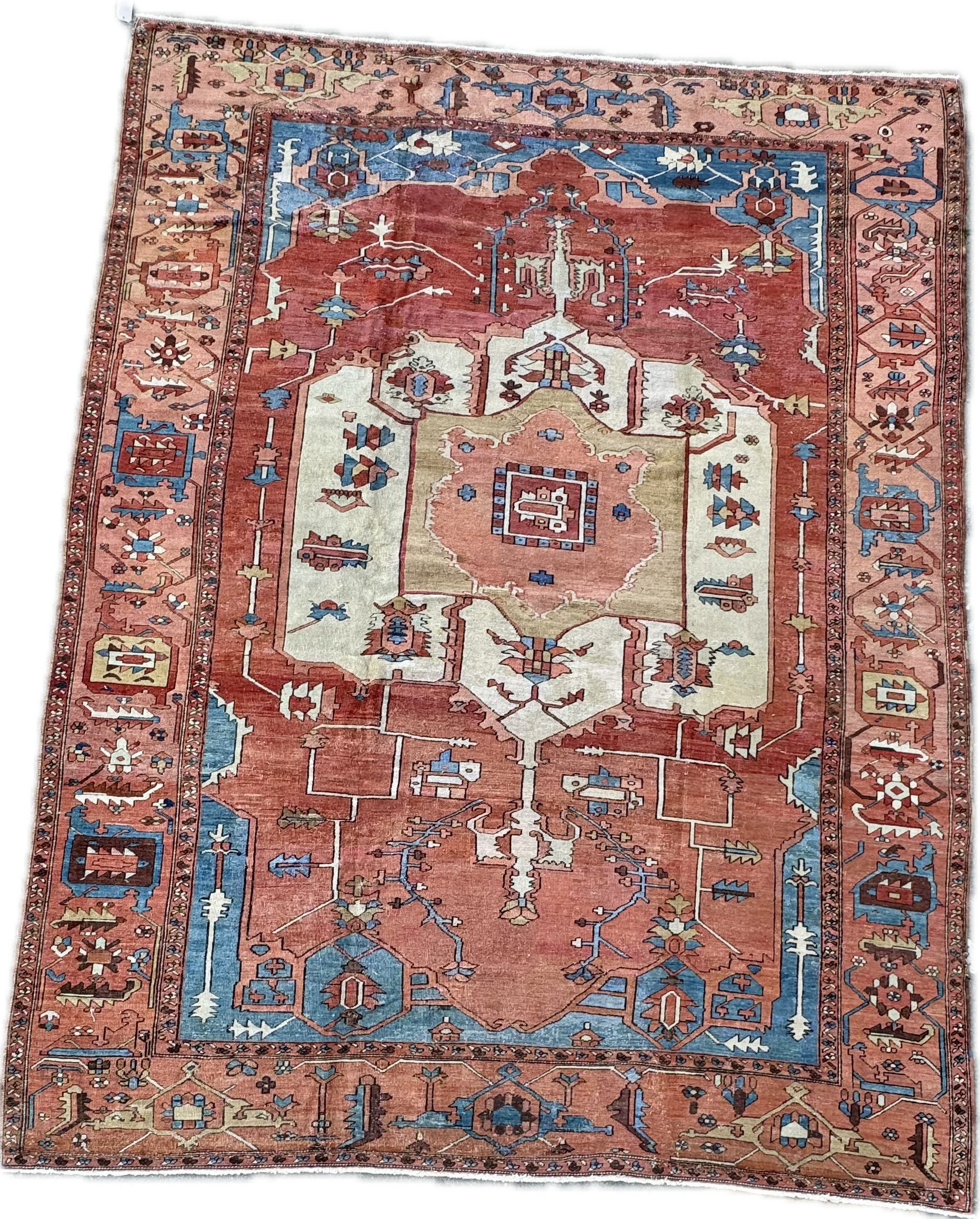 A traditional patterned area rug in shades of red, cream, blue, and beige with geometric and floral motifs.