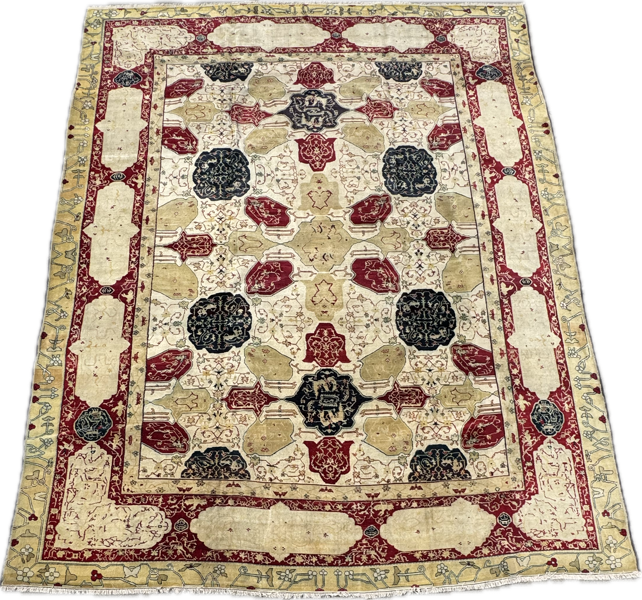 Traditional Persian-style area rug with a central pattern of floral and geometric motifs in black, red, beige, and gold colors, bordered by floral and vine patterns.