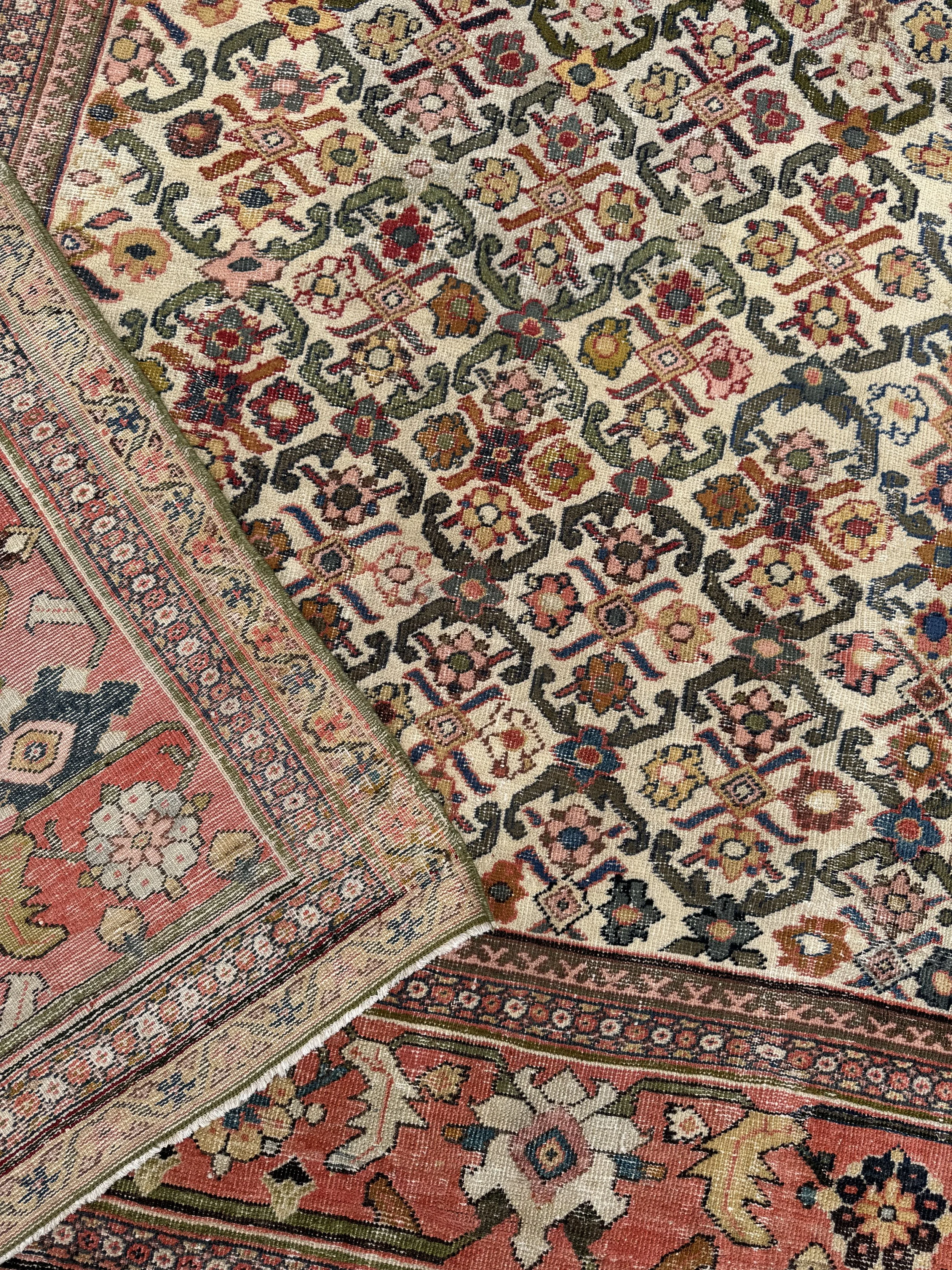 Close-up of an ornate woven area rug with floral and geometric patterns in shades of pink, red, green, yellow, and blue.