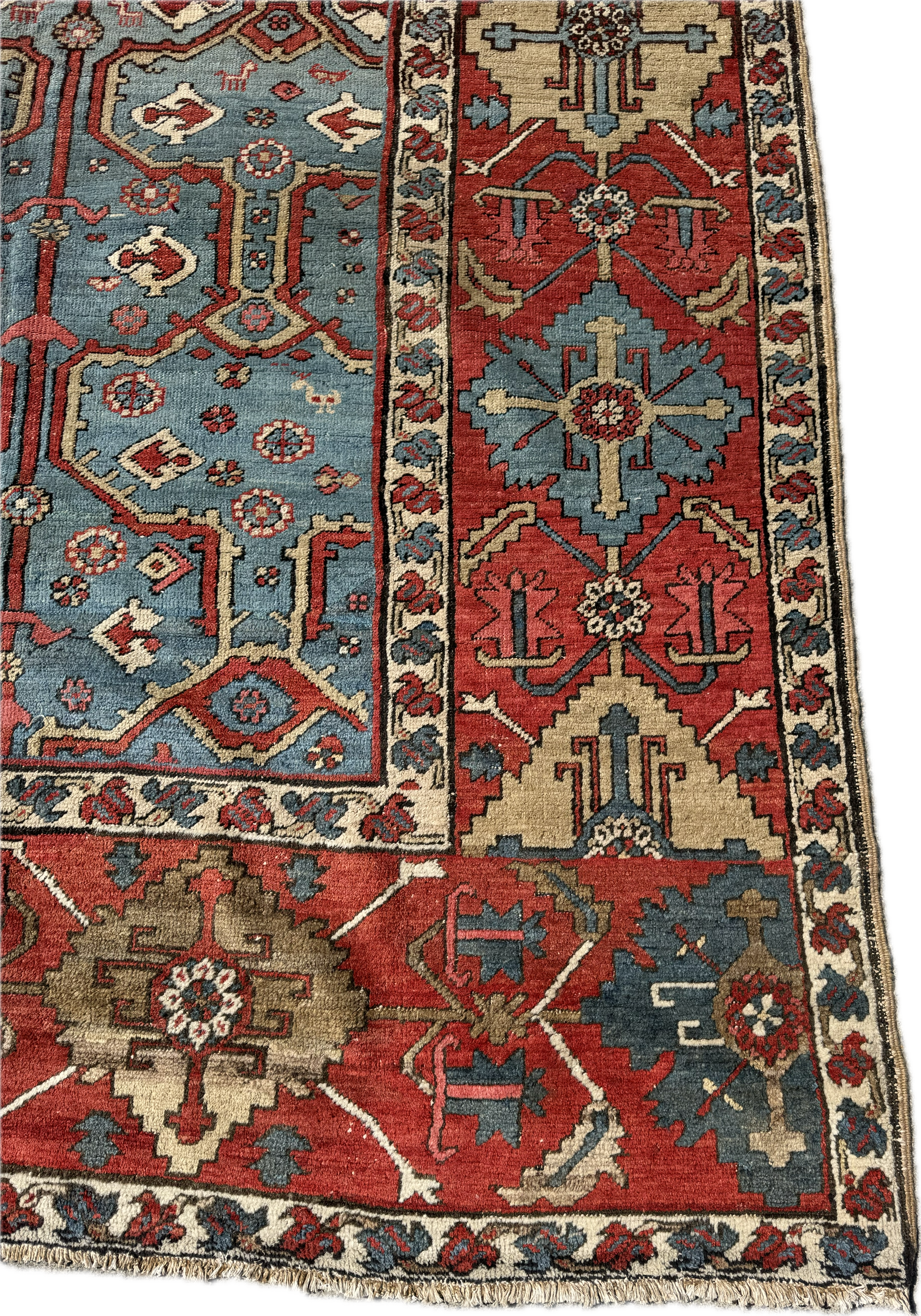 Close-up of a traditional patterned rug with red, blue, beige, and brown colors, featuring geometric and floral motifs.