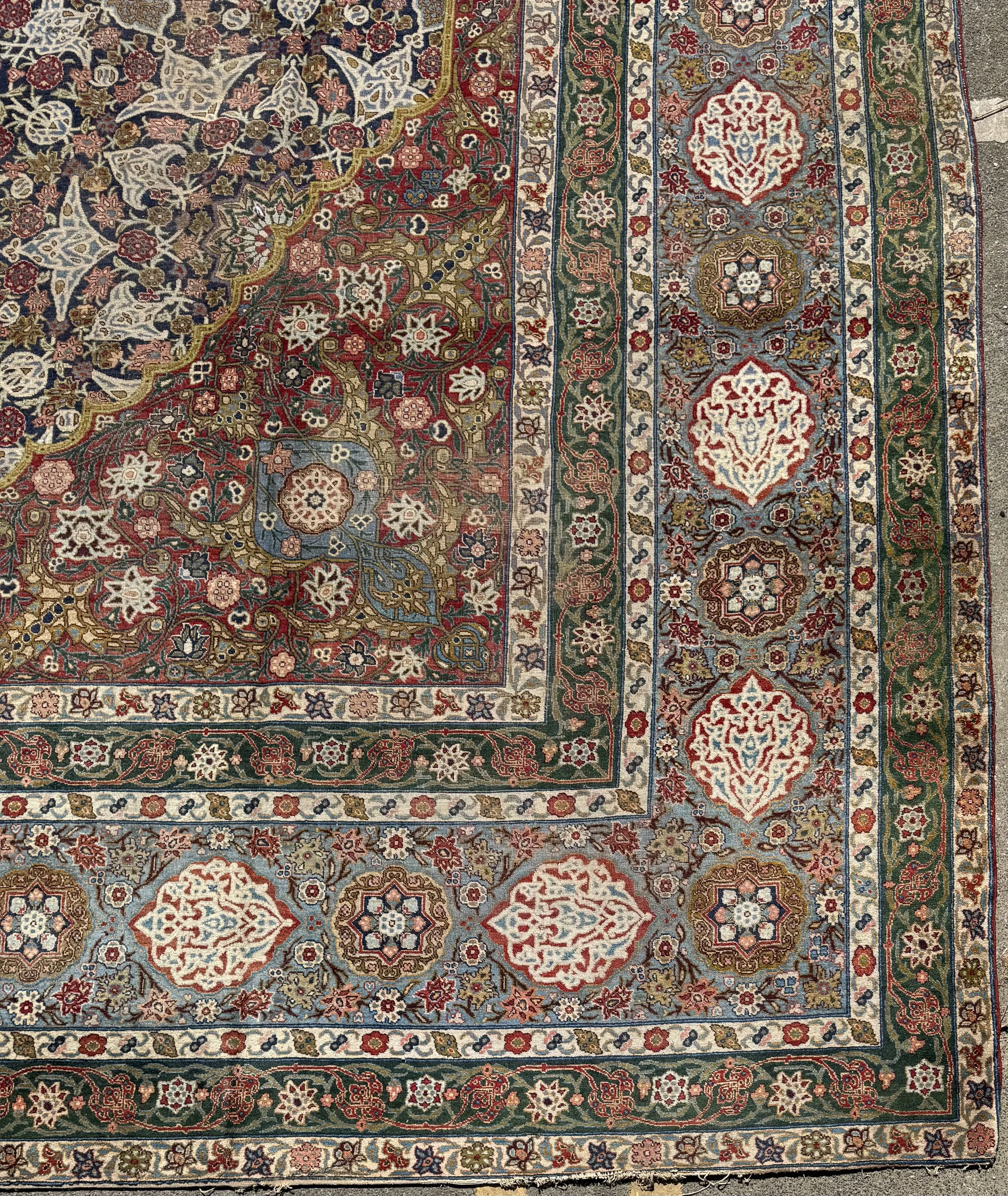 Close-up of traditional patterned area rug with intricate floral and geometric designs in red, cream, blue, green, and gold colors.