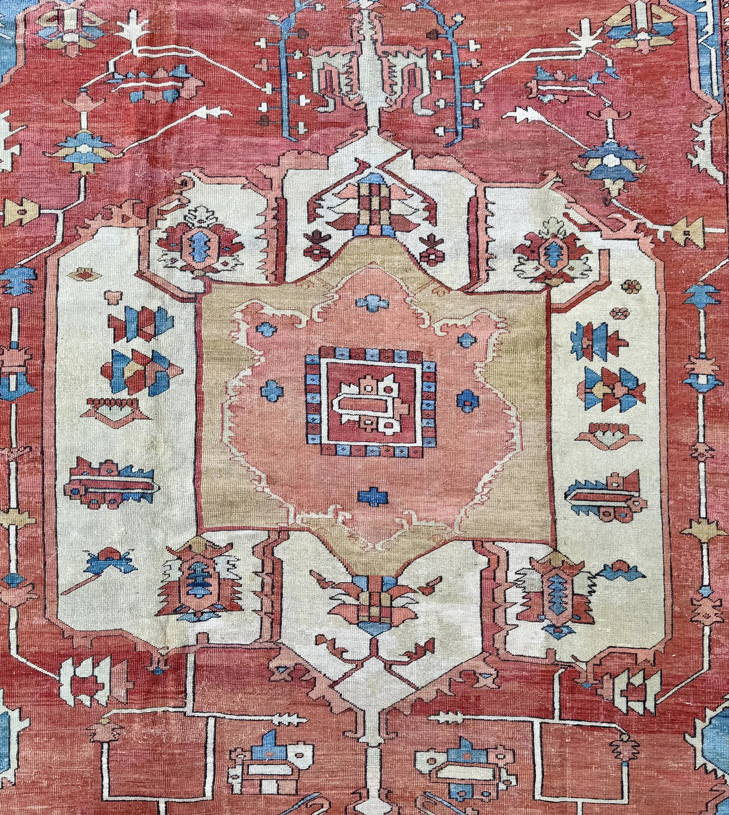 Close-up of a traditional Oriental rug with intricate geometric patterns in red, cream, blue, and beige colors.