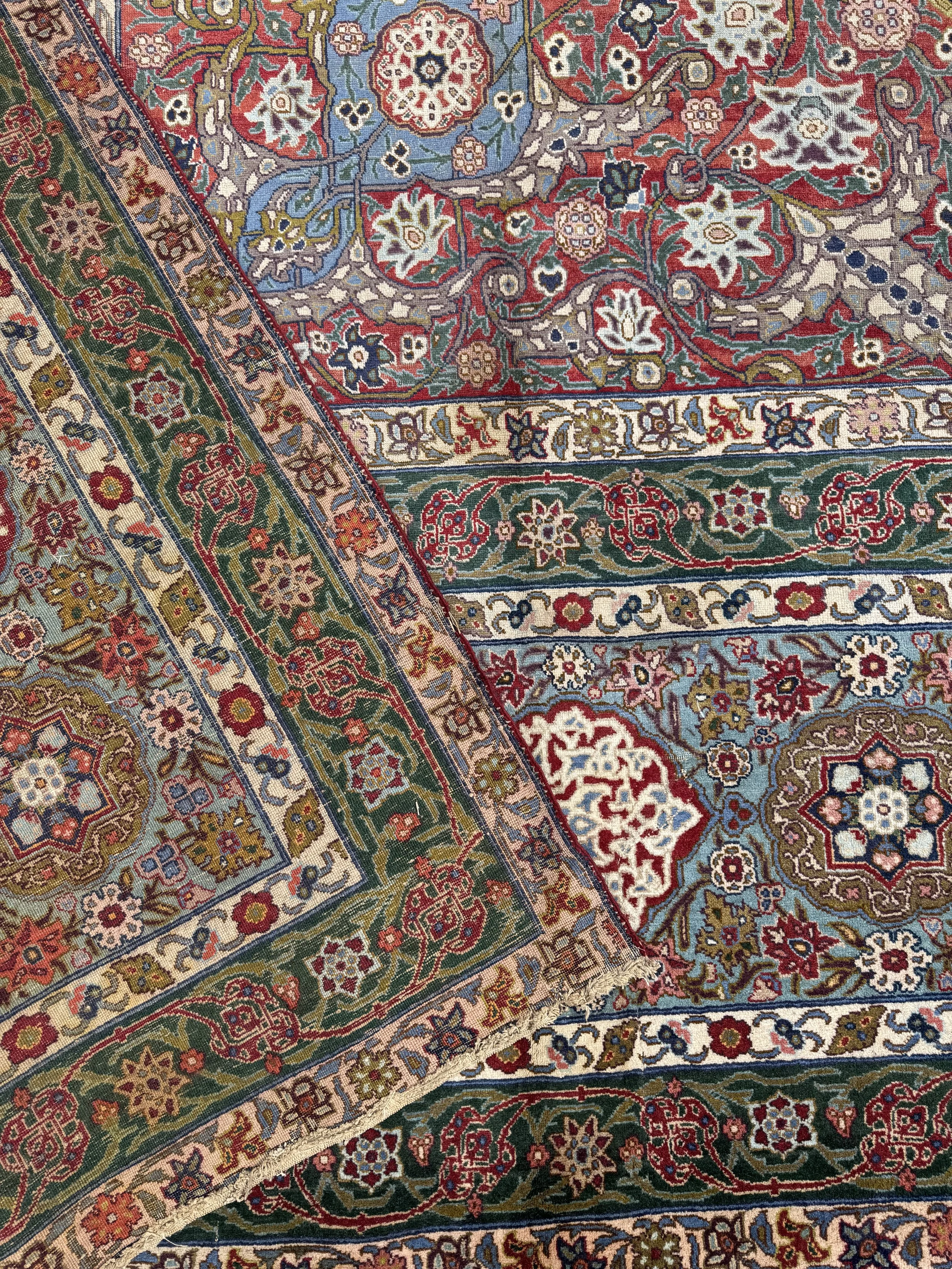 Close-up of a detailed, multicolored Persian-style rug with floral and geometric patterns.