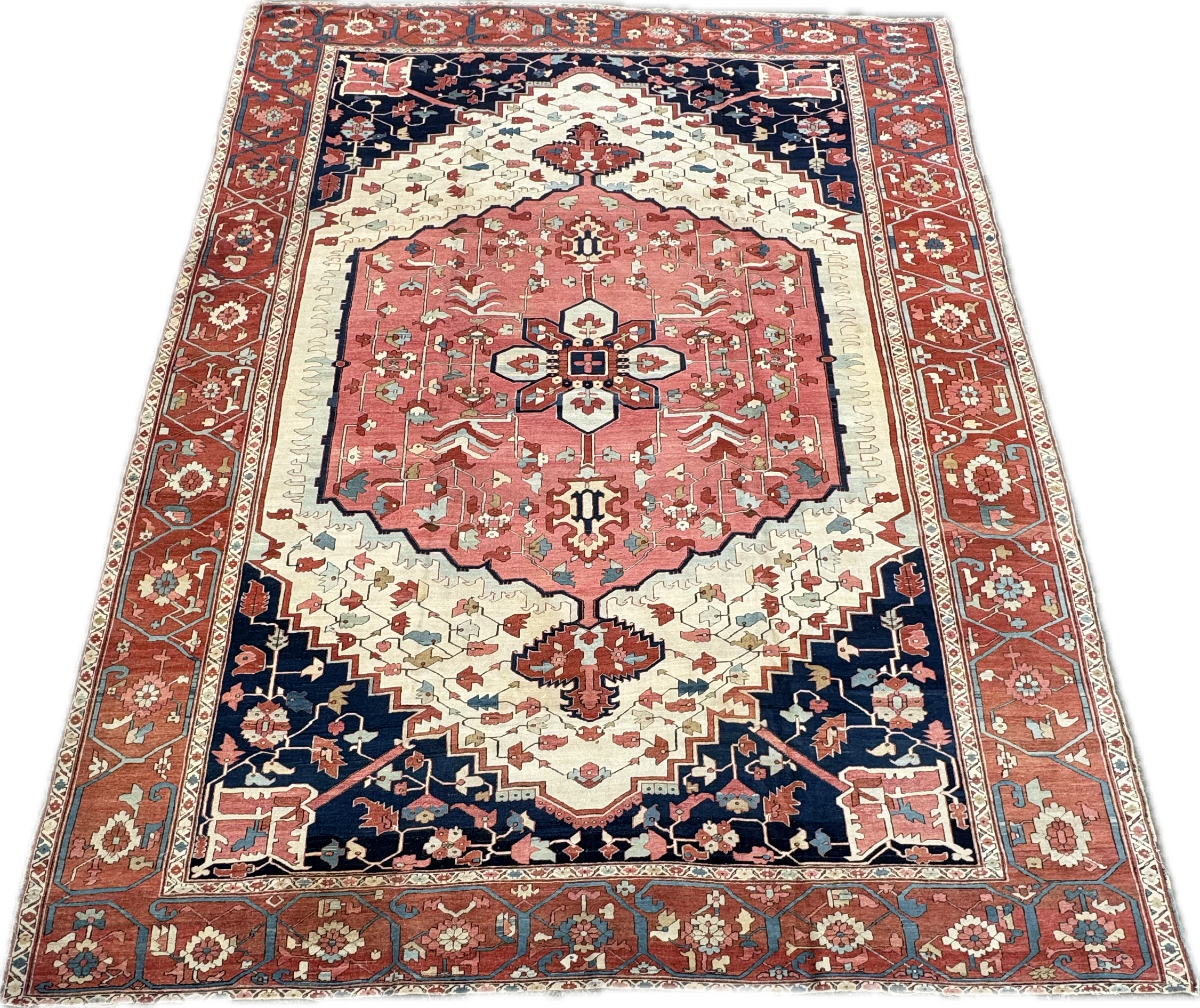 Traditional Persian rug with red, navy, cream, and pink colors featuring geometric and floral patterns