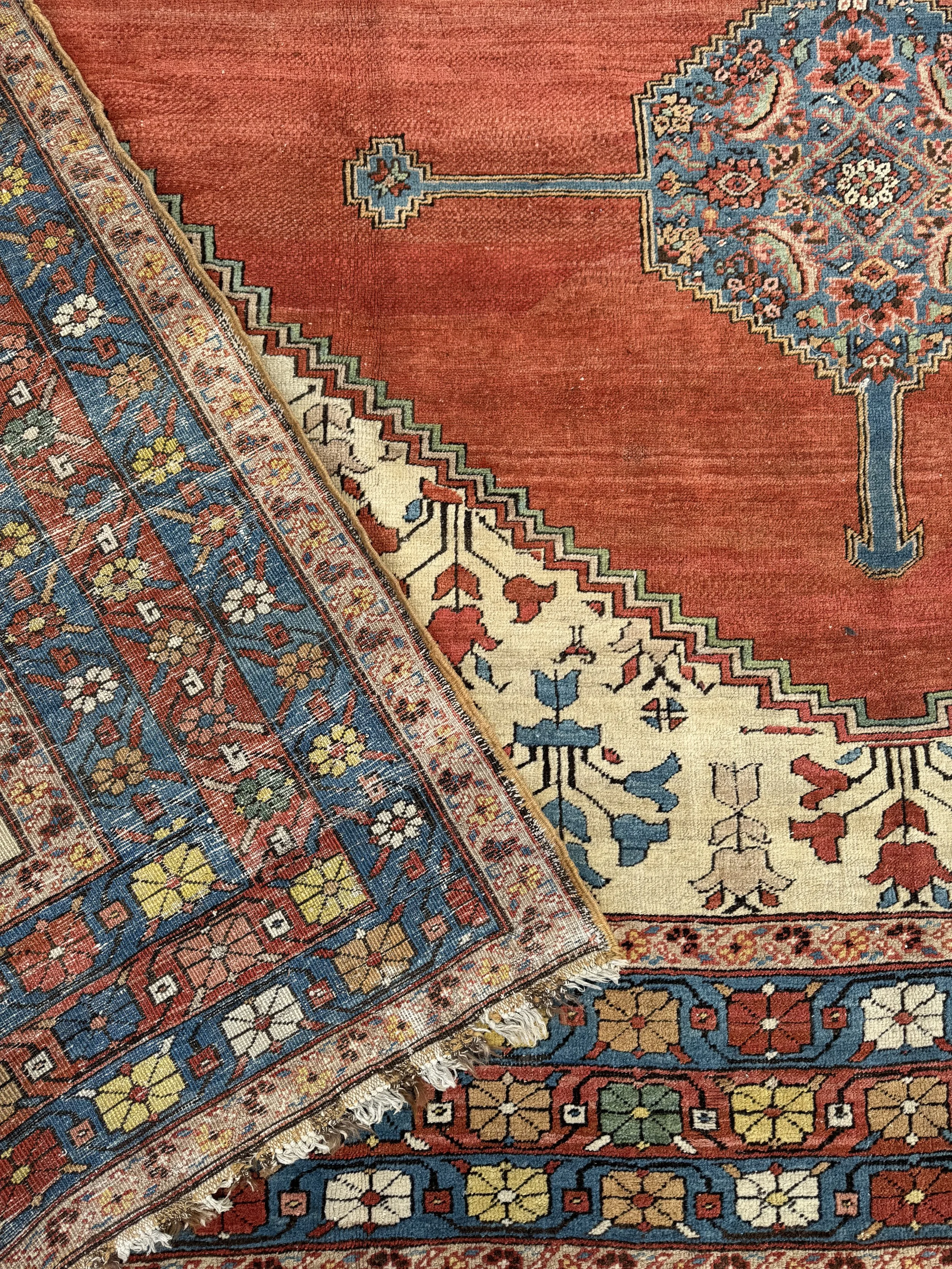 Close-up of overlapping colorful traditional Persian rugs with intricate floral and geometric patterns.